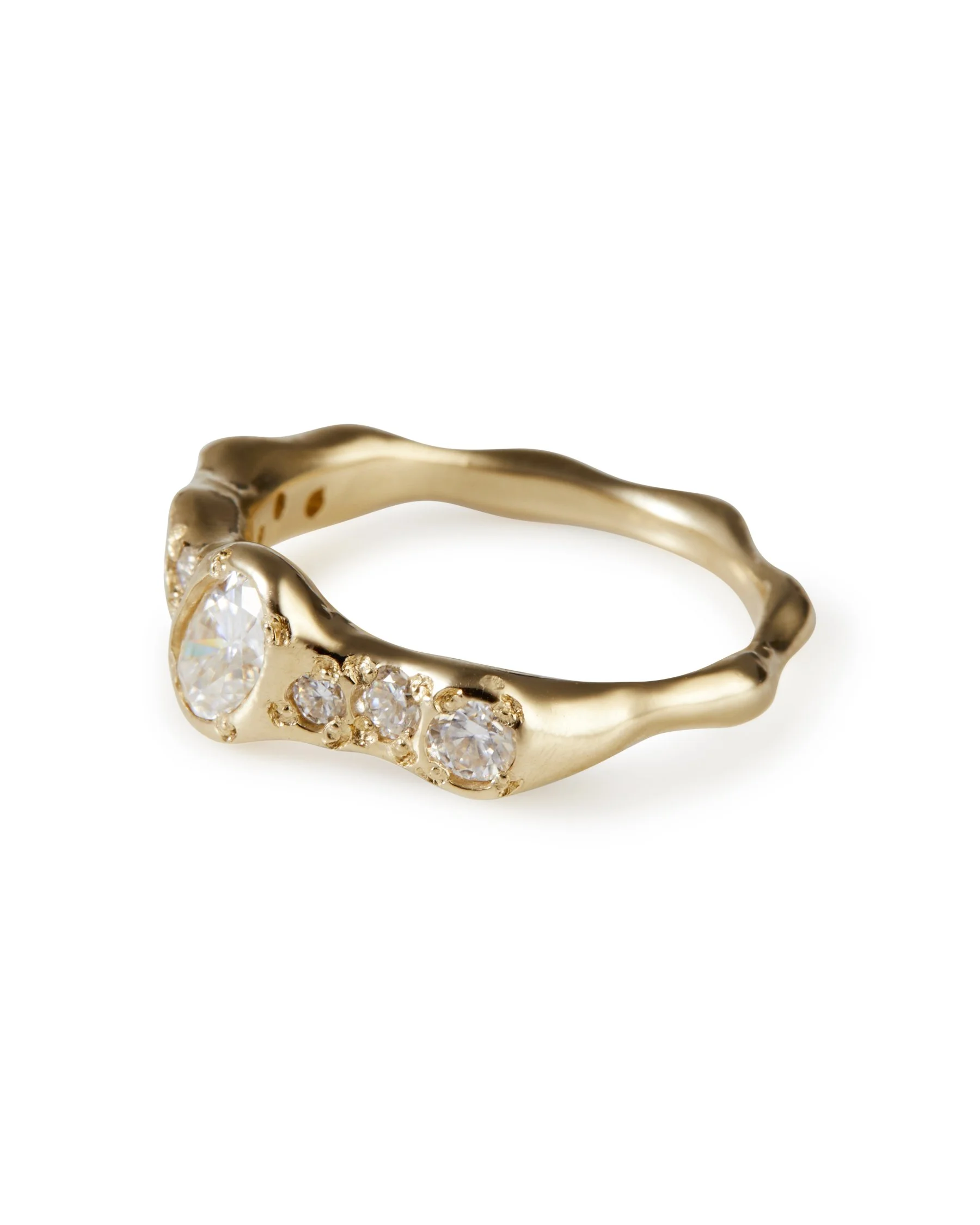 A yellow gold molten ring with moissanites and one central larger tilted moissanite - side view