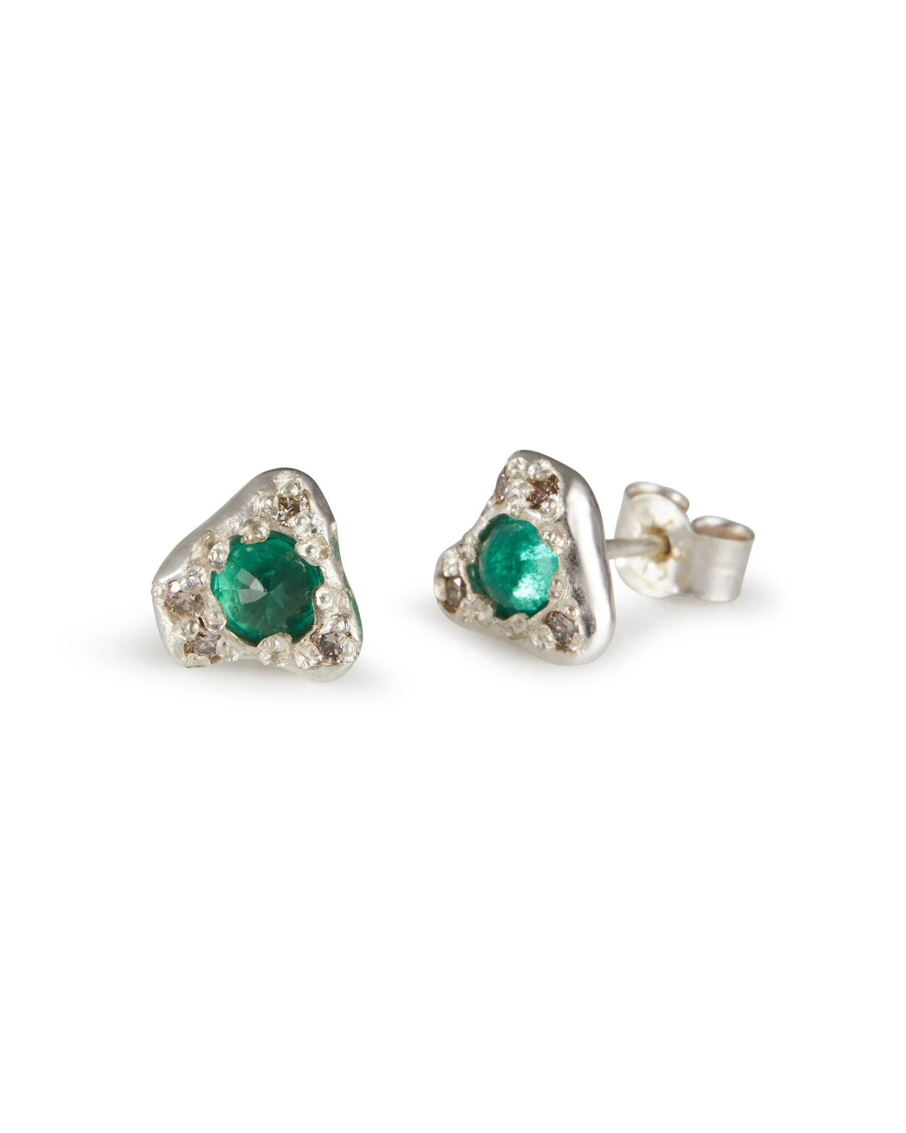 A pair of silver organic shaped studs with a central emerald set upside down and brown diamonds scattered around