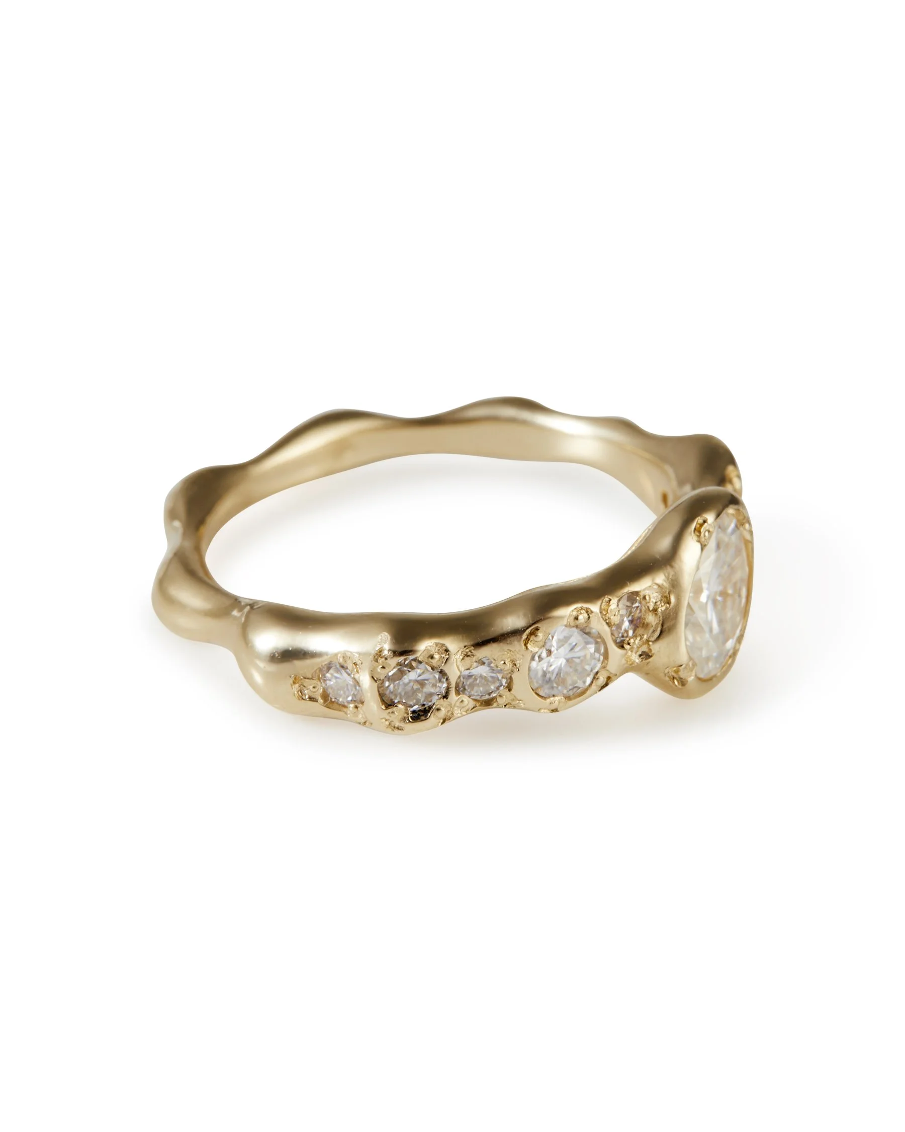 A yellow gold molten ring with moissanites and one central larger tilted moissanite - side view
