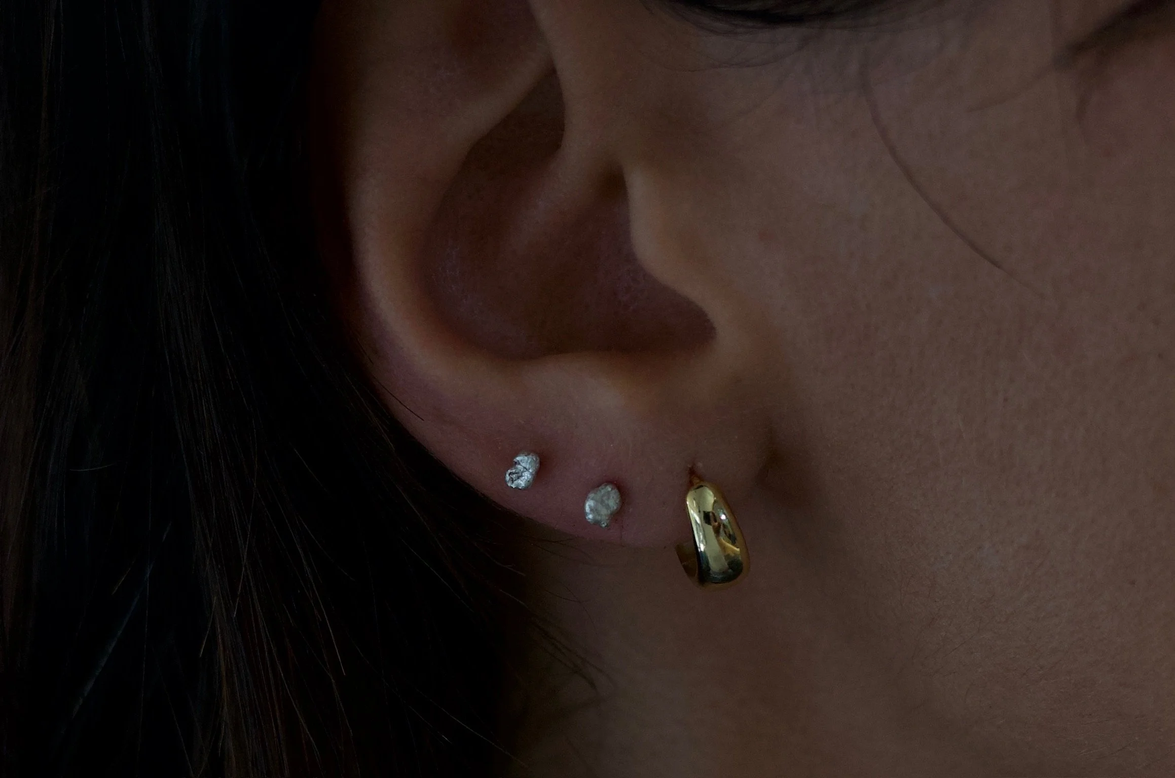 Textured sterling silver studs. The studs are mismatched and in an ear