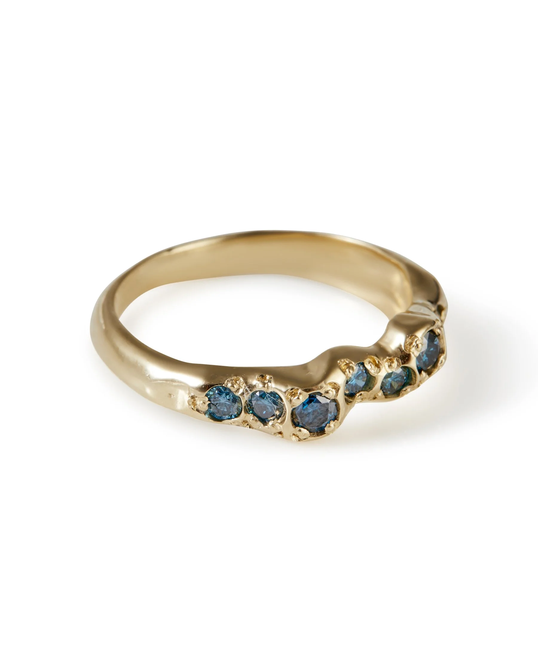 A molten gold ring with a line of blue diamonds set into it - side view