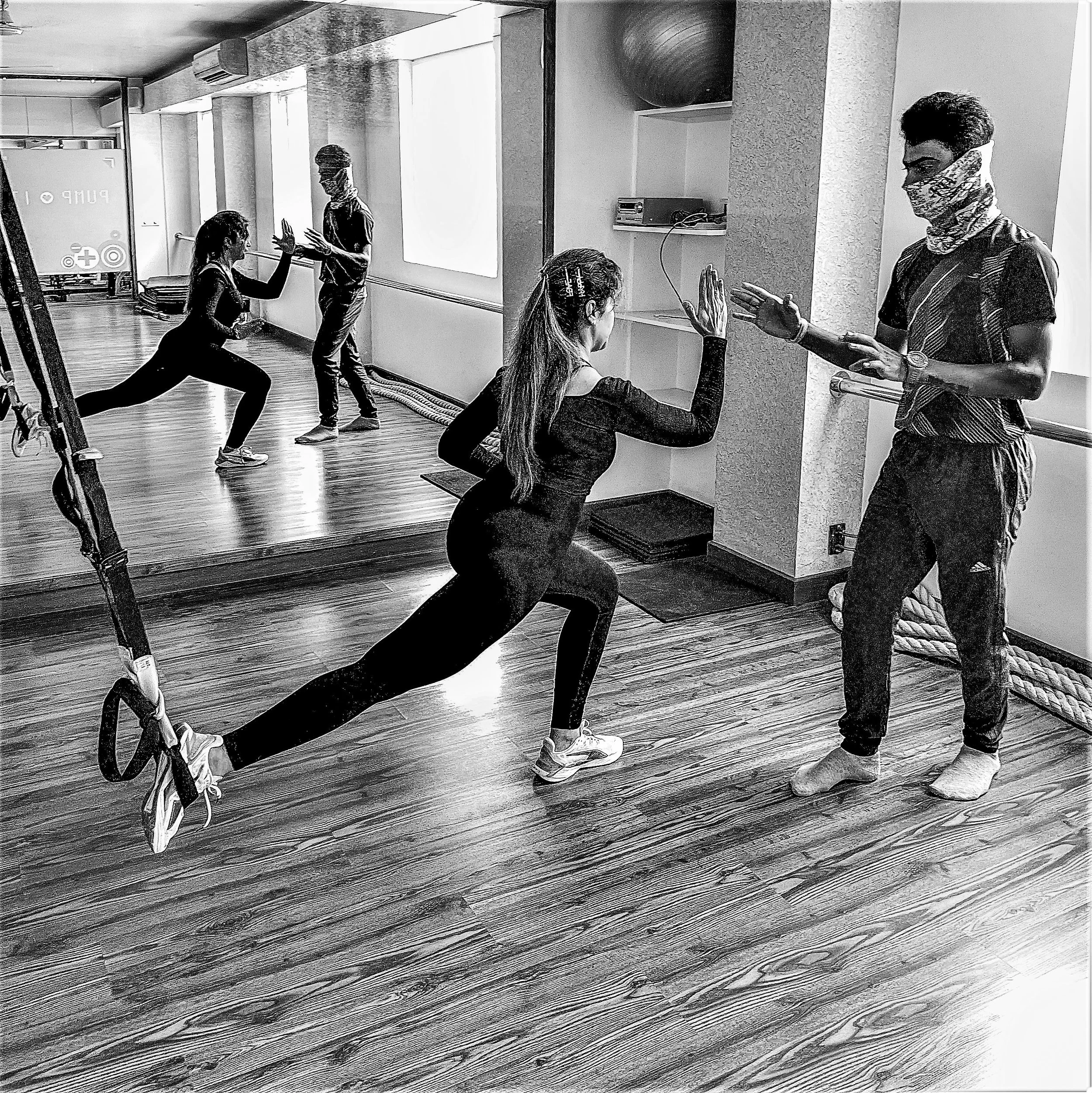 Client performing TRX suspension exercises under instructor guidance at The Zone