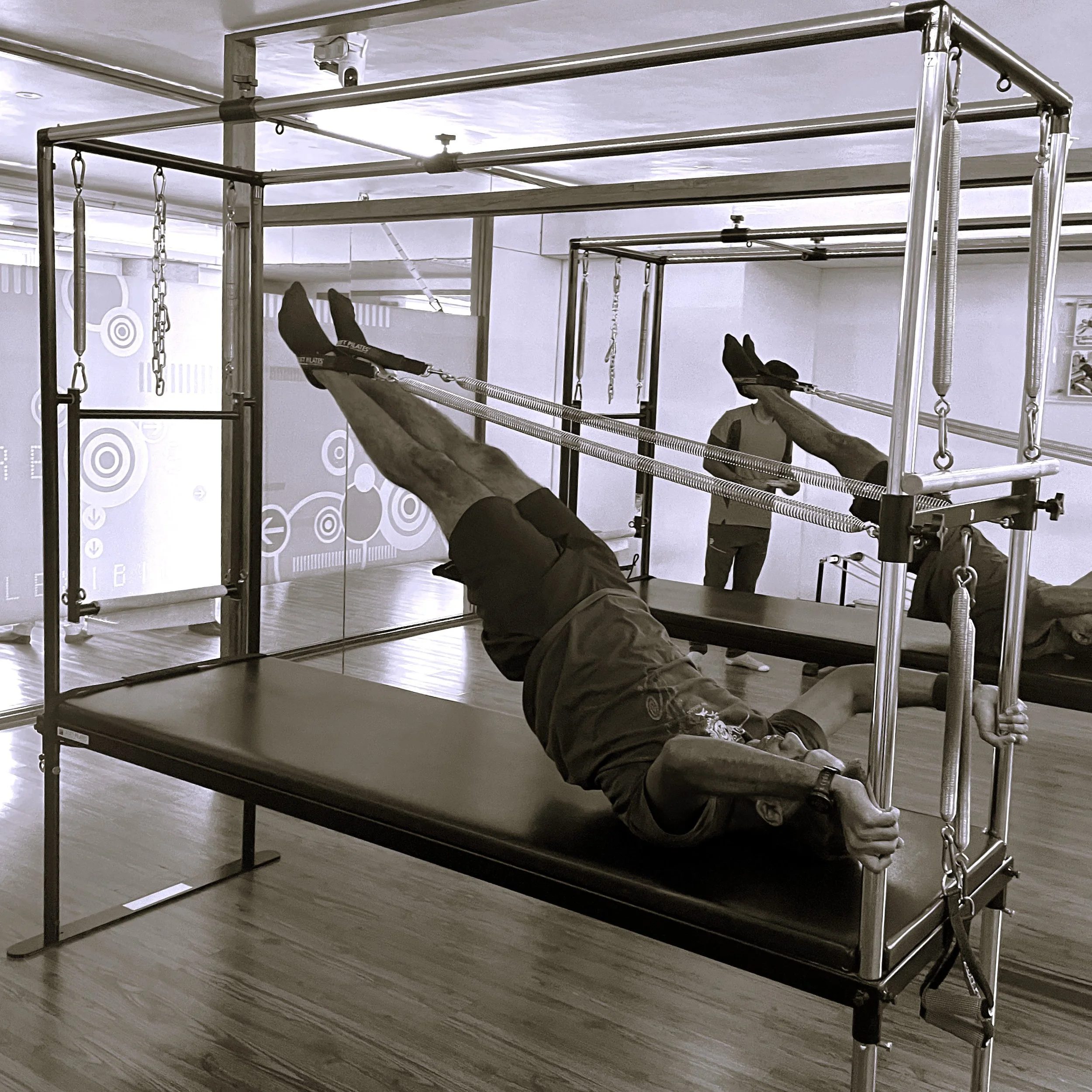 Client performing a leg exercise on the Cadillac Reformer during a Pilates personal training session at The Zone Mind and Body Studio, Bangalore