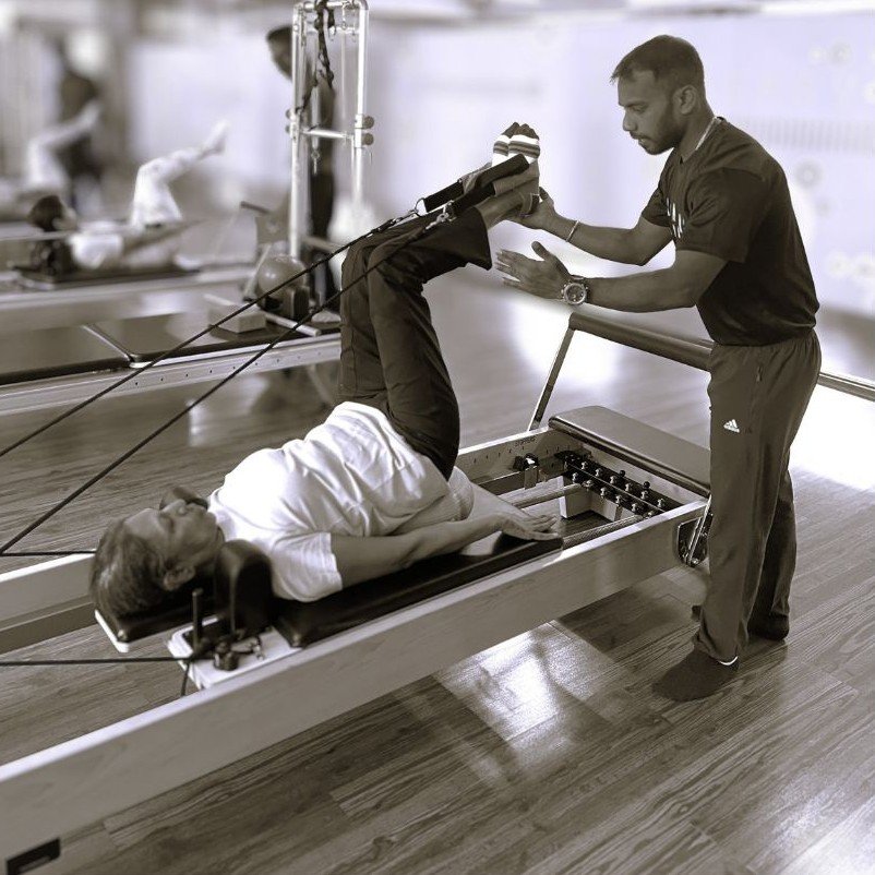 Pilates instructor guiding a client through a Reformer exercise at The Zone Studio, Bangalore