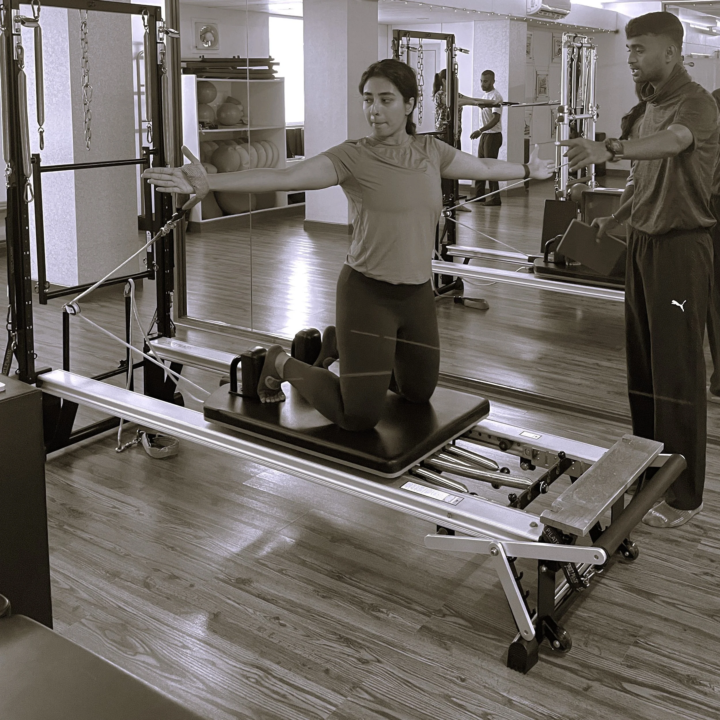 Instructor taking Pilates personal training session on the reformer