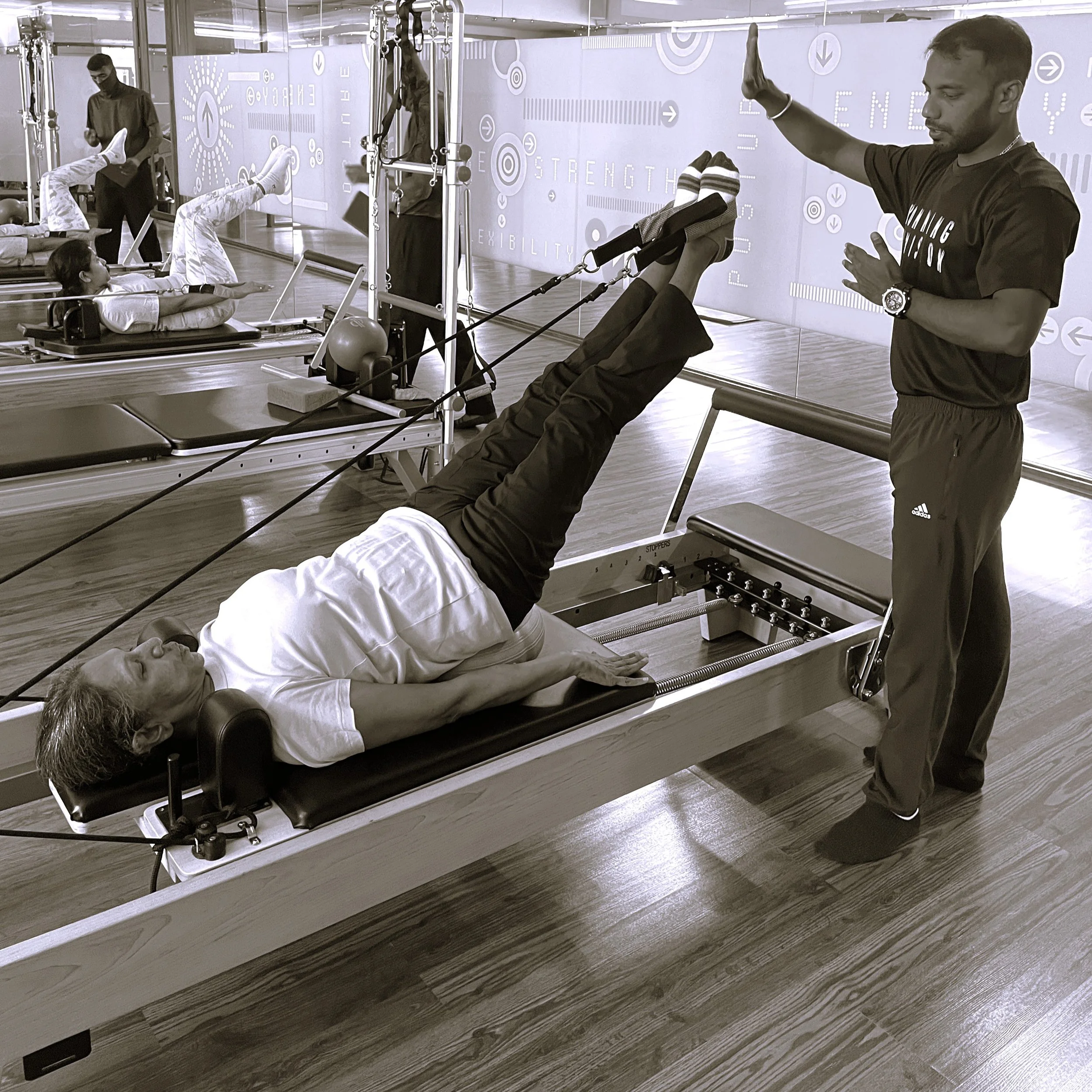 Instructor training client on the Pilates reformer