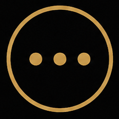 Close-up of a black round button with a gold border and three gold dots in the center.