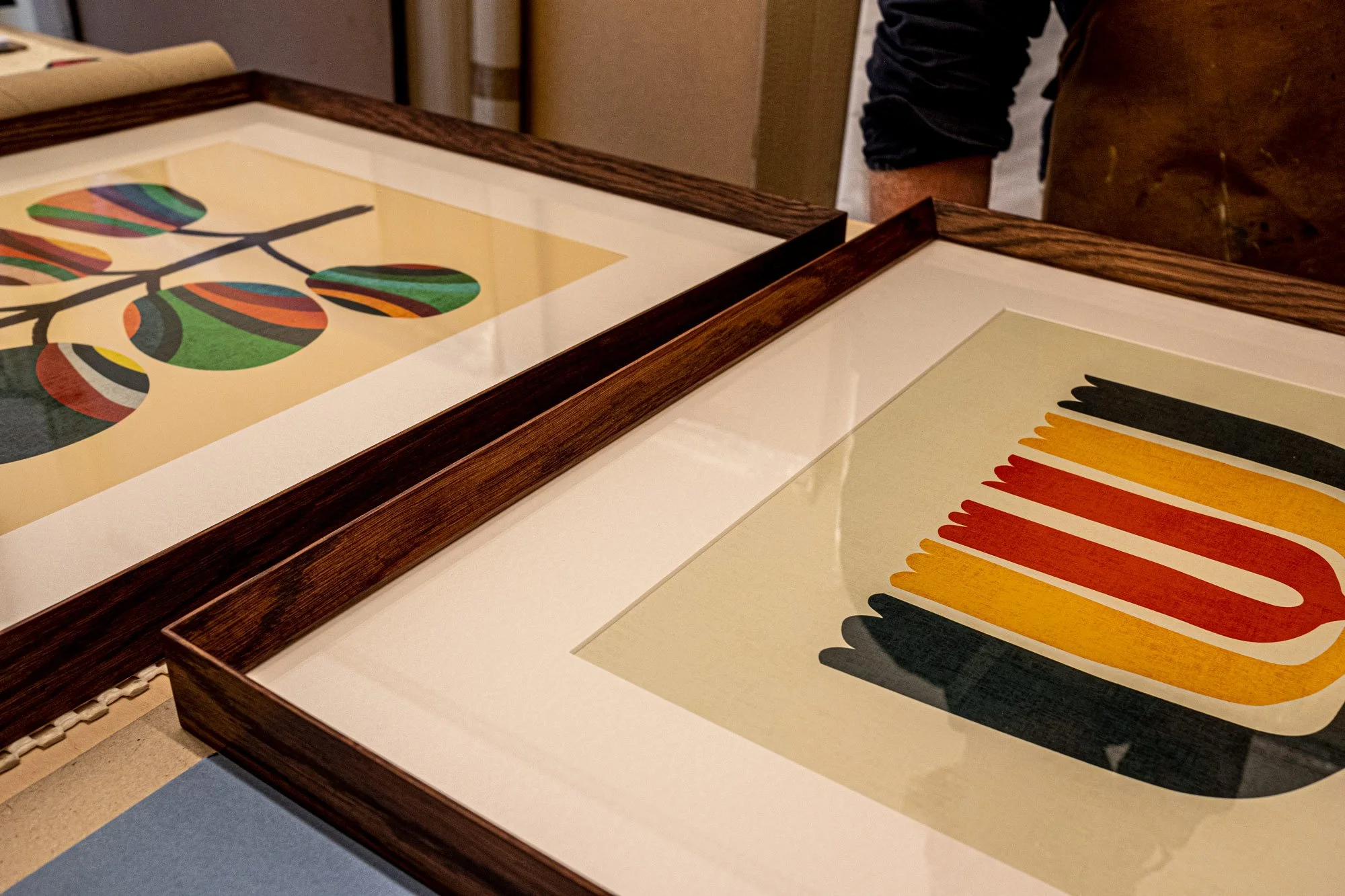 two colourful artworks in dark wooden frames.jpg