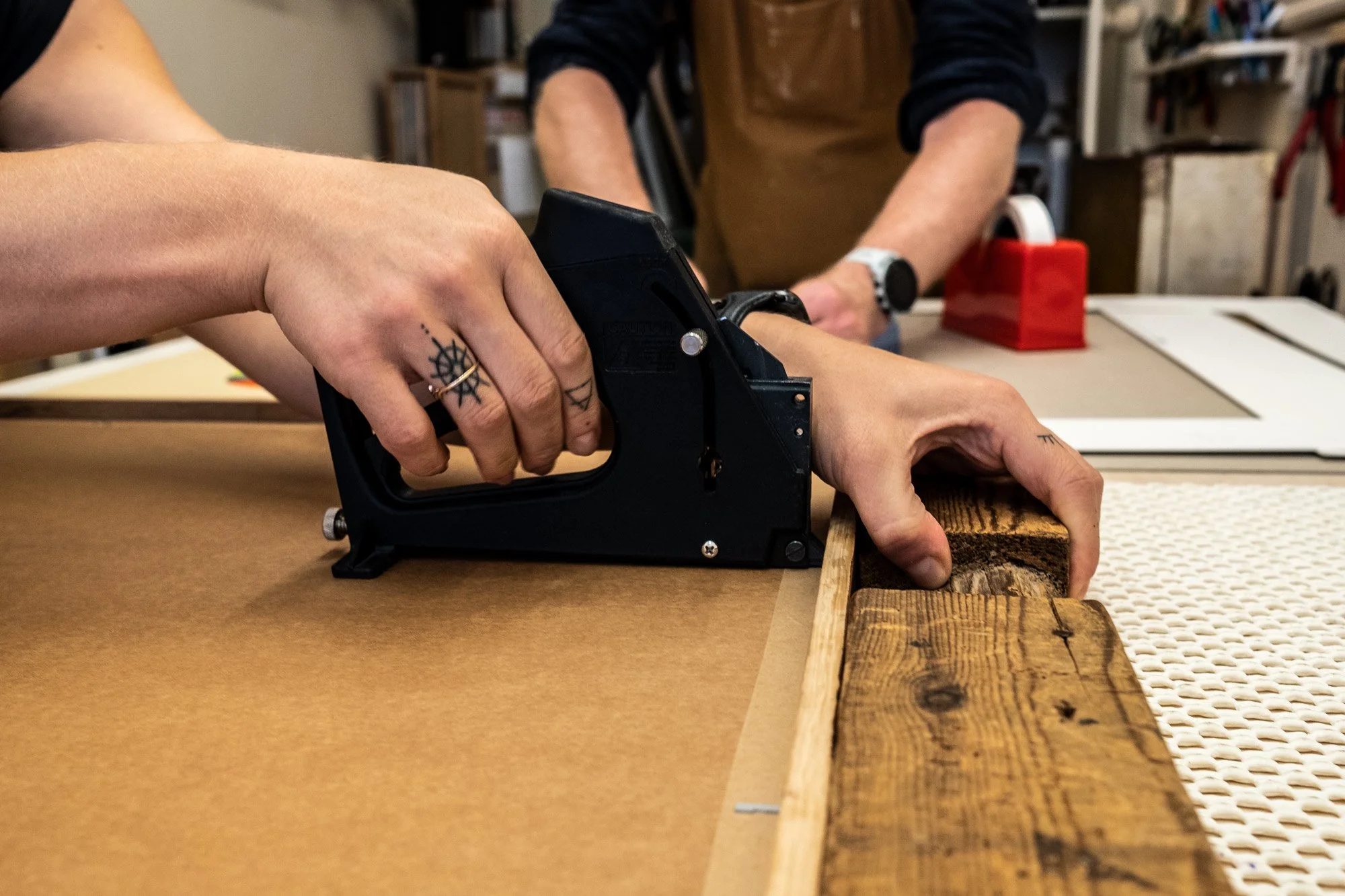 white female tatooed hands stapling picture frame.jpg