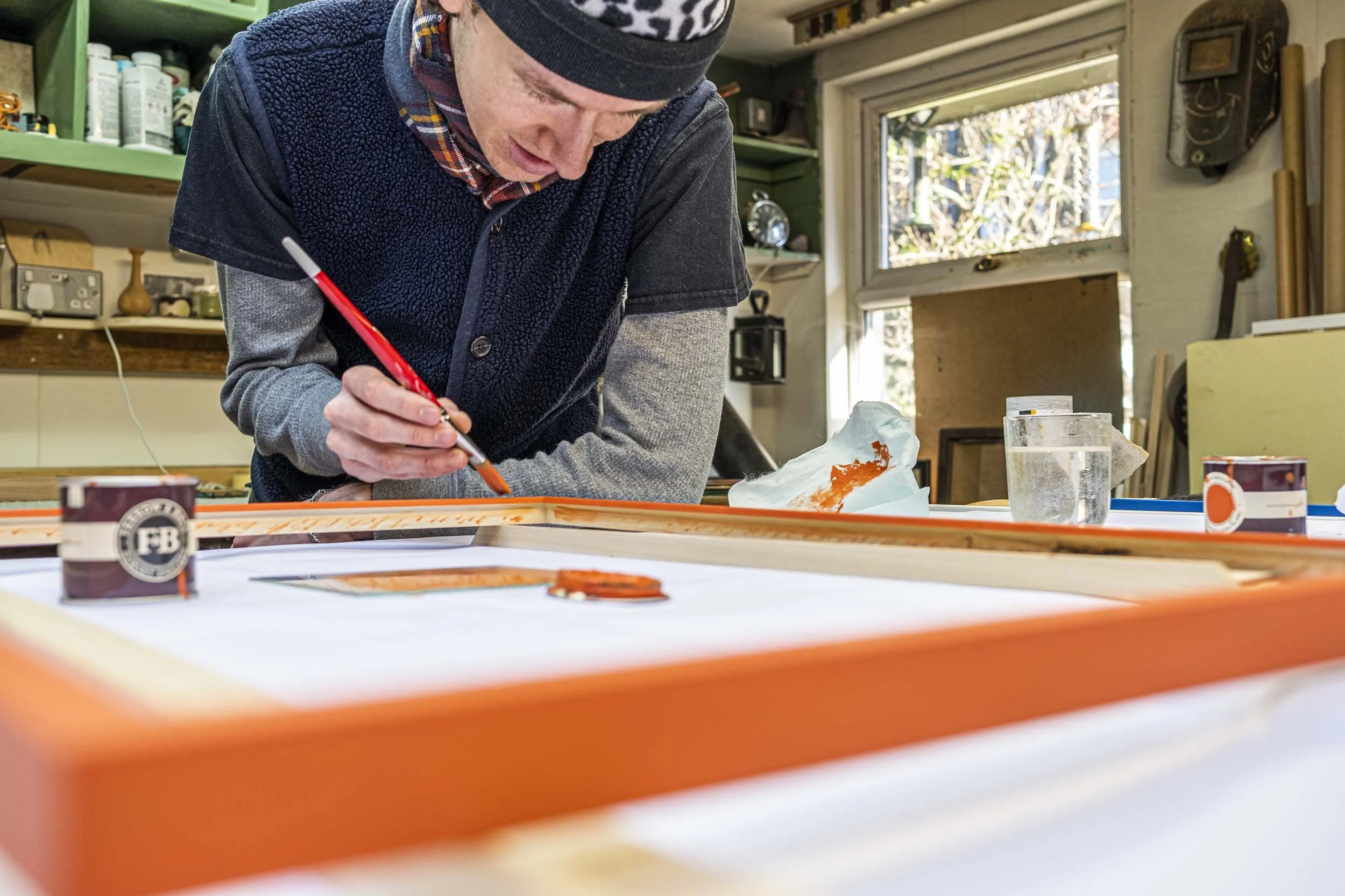 white male painting picture frame orange.jpg