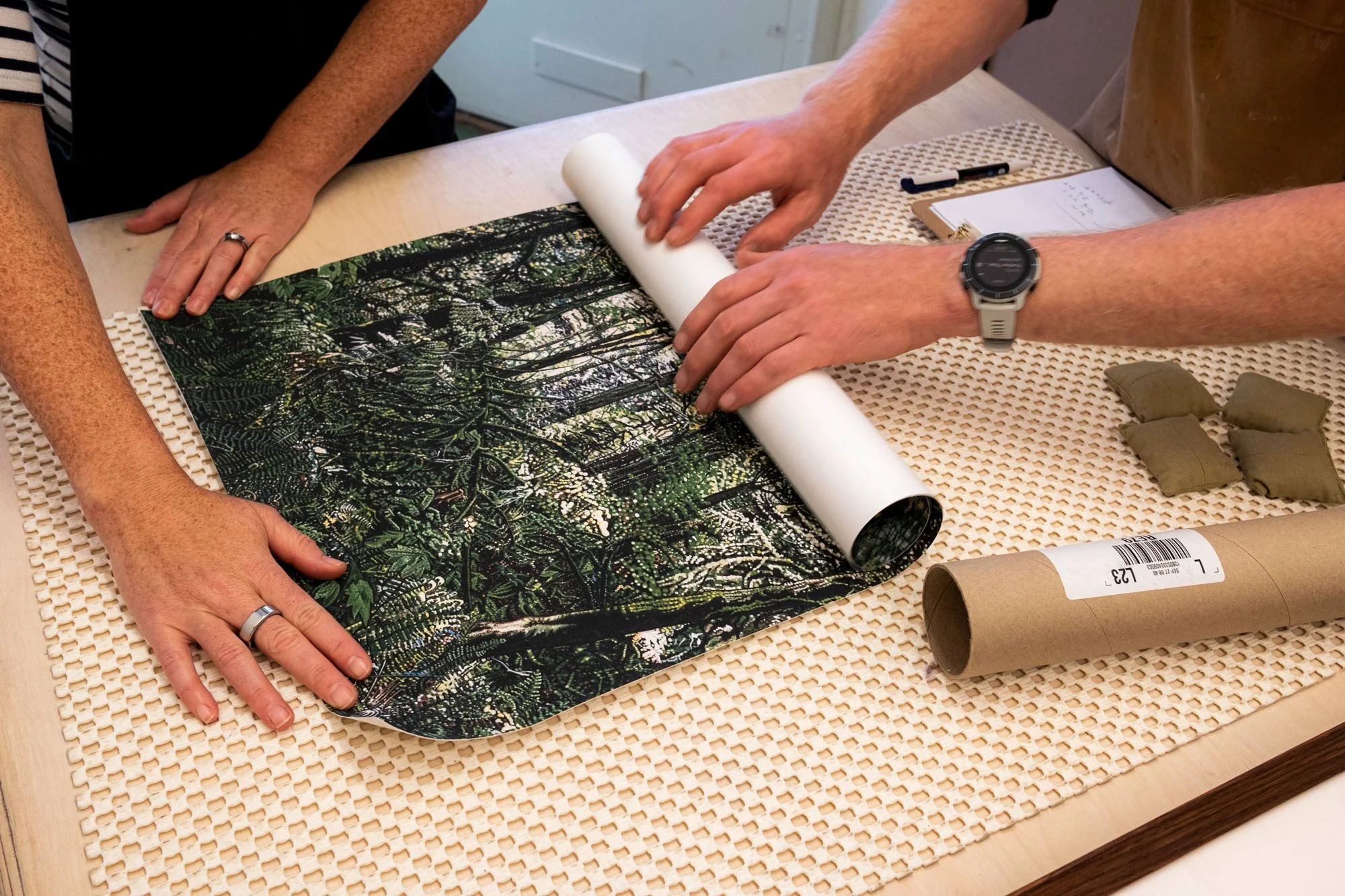 two white people laying out a forest artwork on a table.jpg