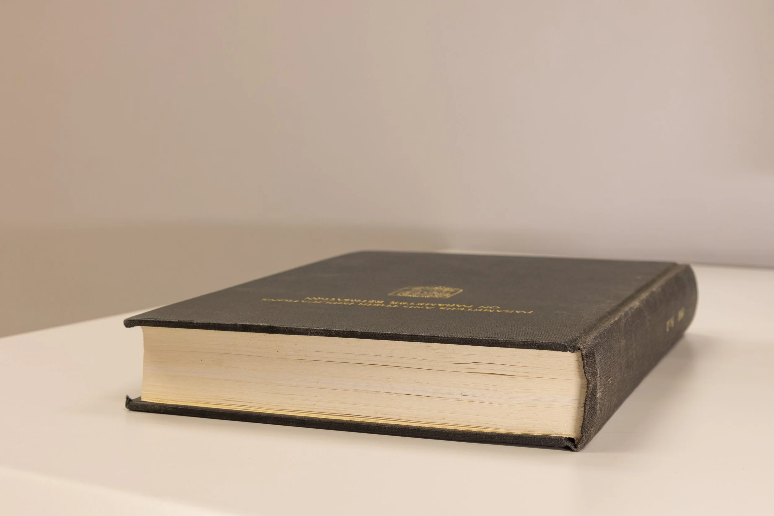 A book lying on a white surface against a white background.