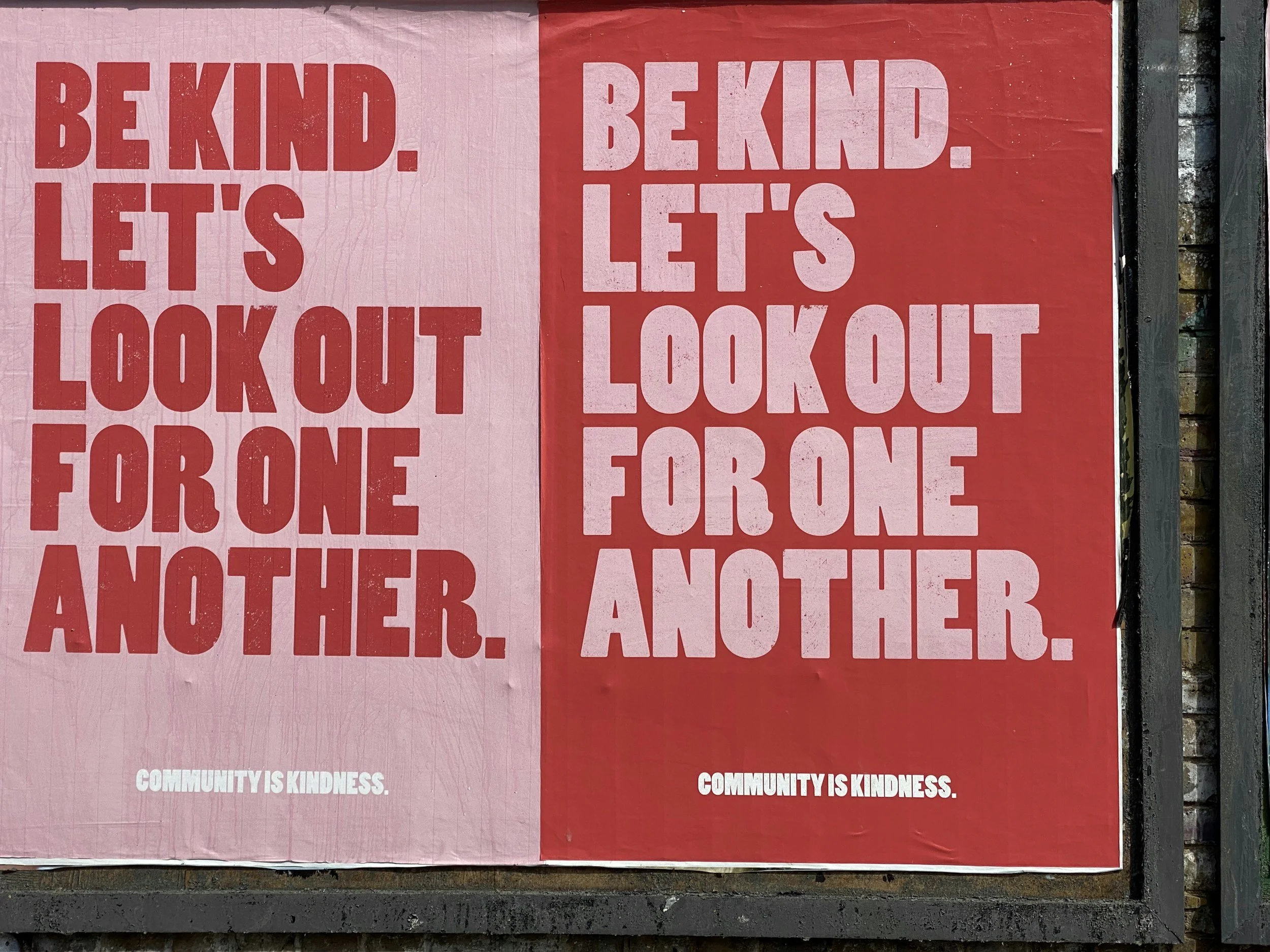 Posters with red and pink backgrounds displaying the message, "Be kind. Let's look out for one another." and "Community is kindness."