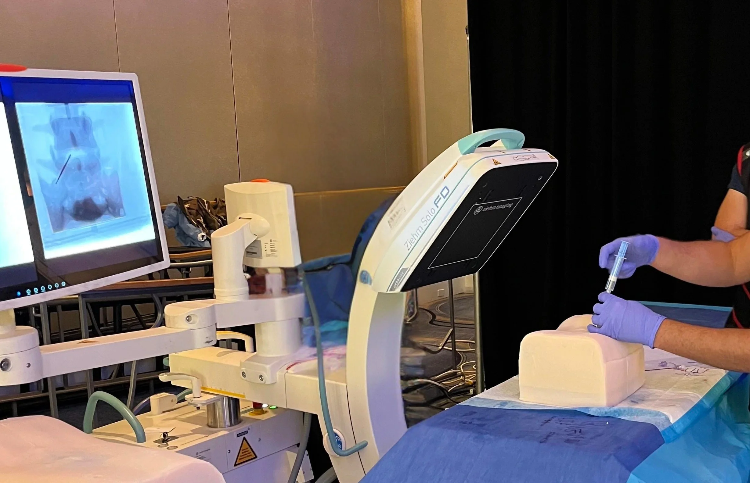 Synthetic L2 to S1 thoracolumbar spine being X-Rayed onon table.