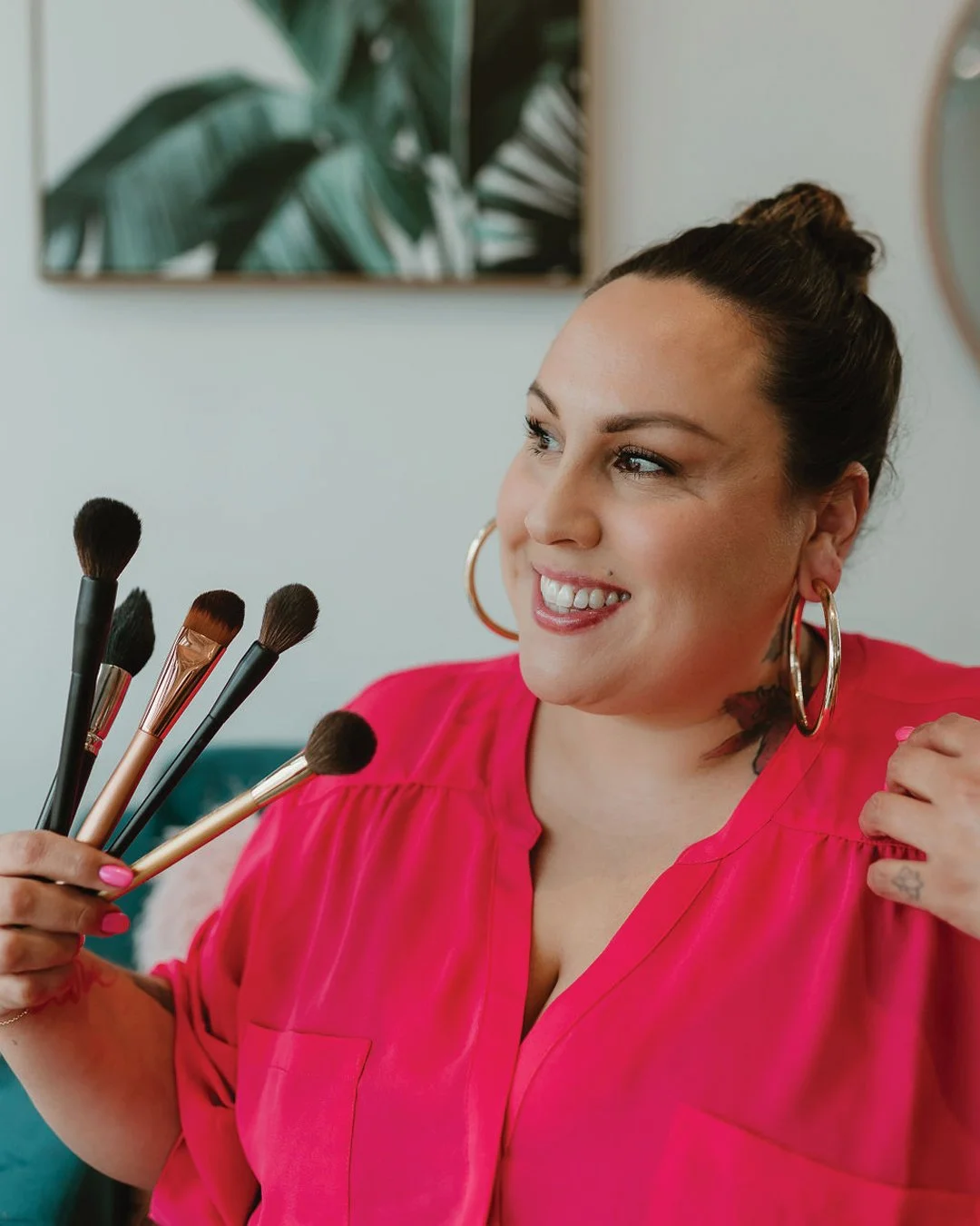 Makeup artist holding brushes in a studio