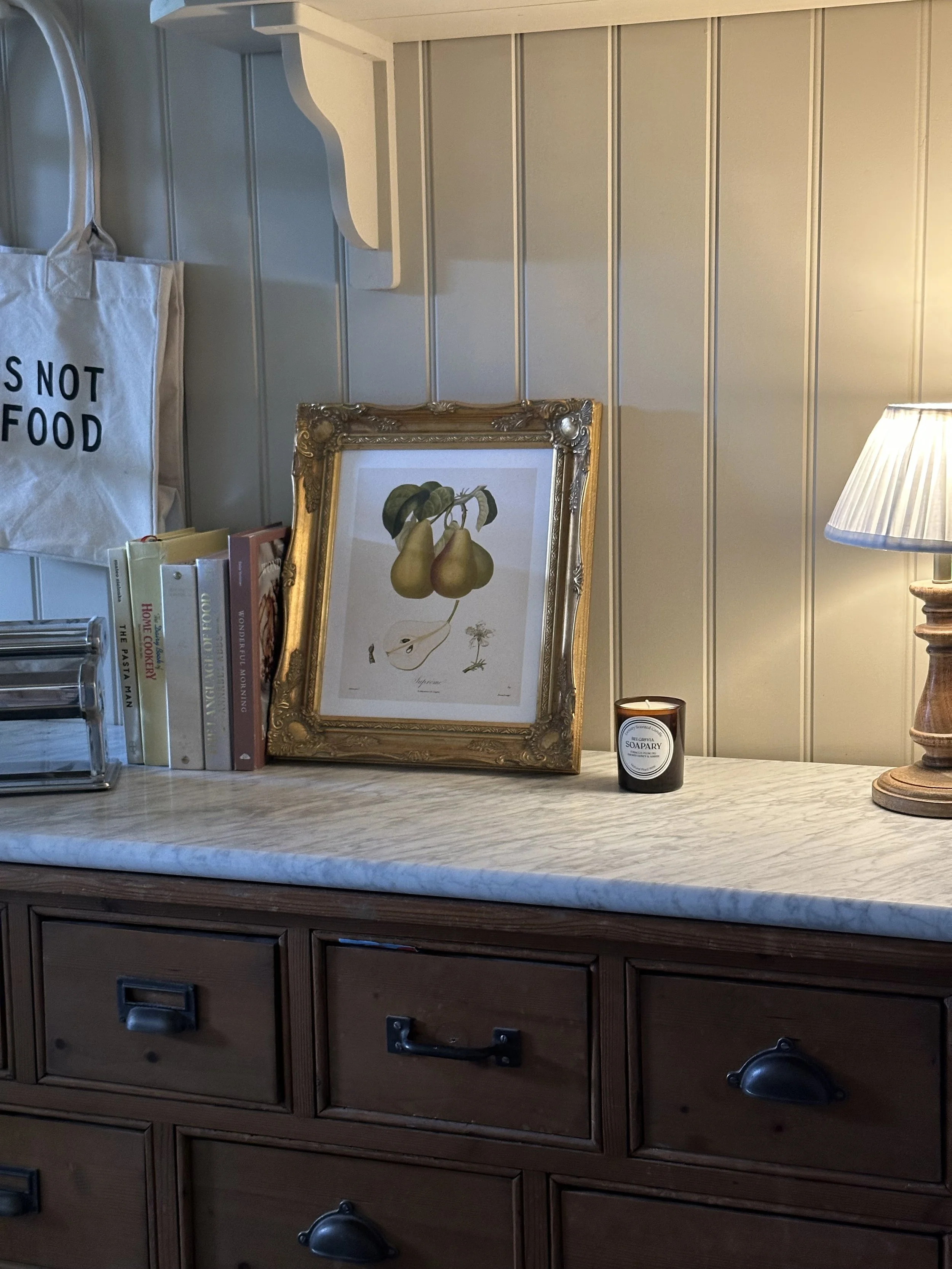 candle on kitchen top with gorgeous pear artwork behind