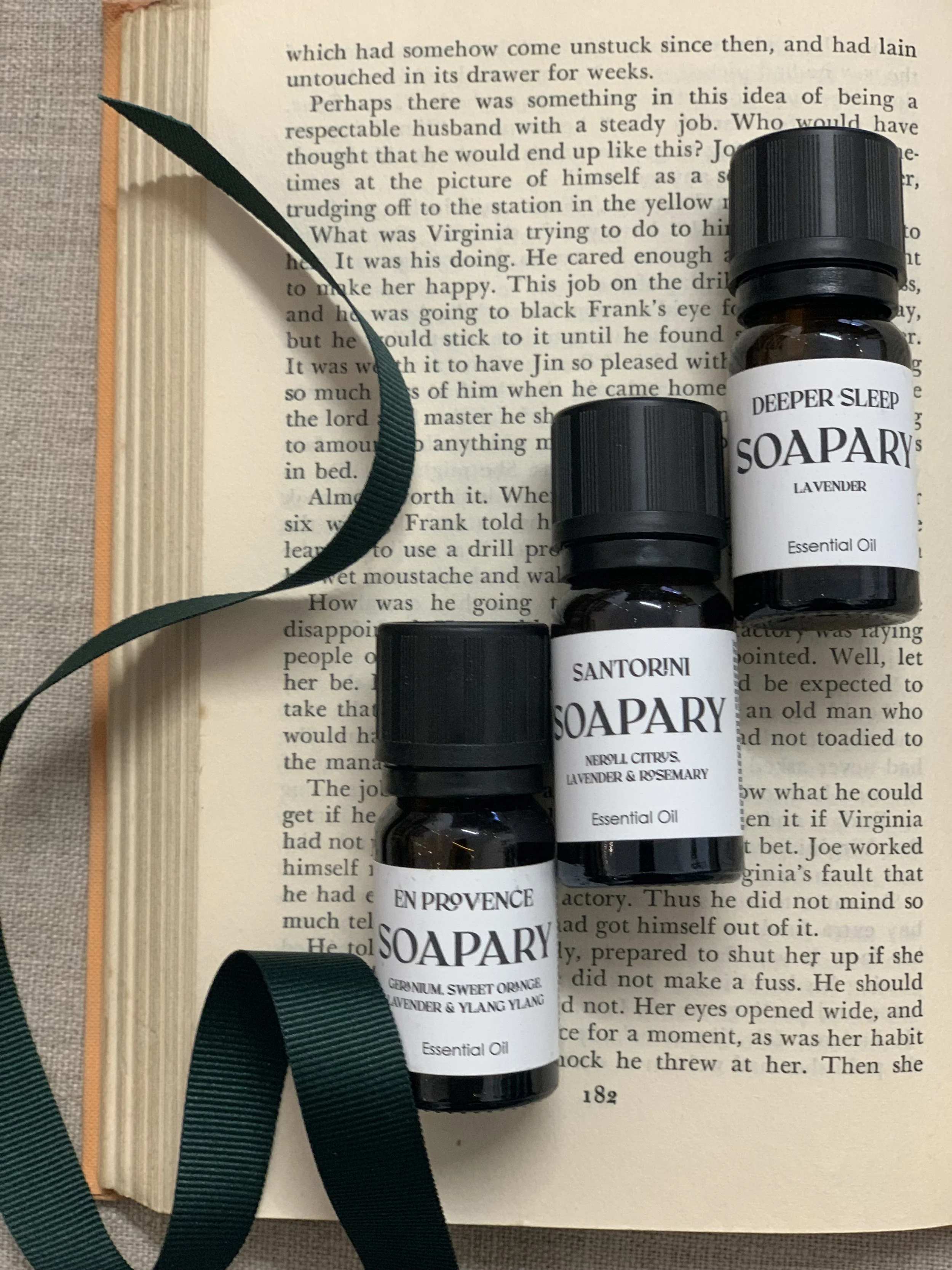 essential oils laid on an open book with a ribbon