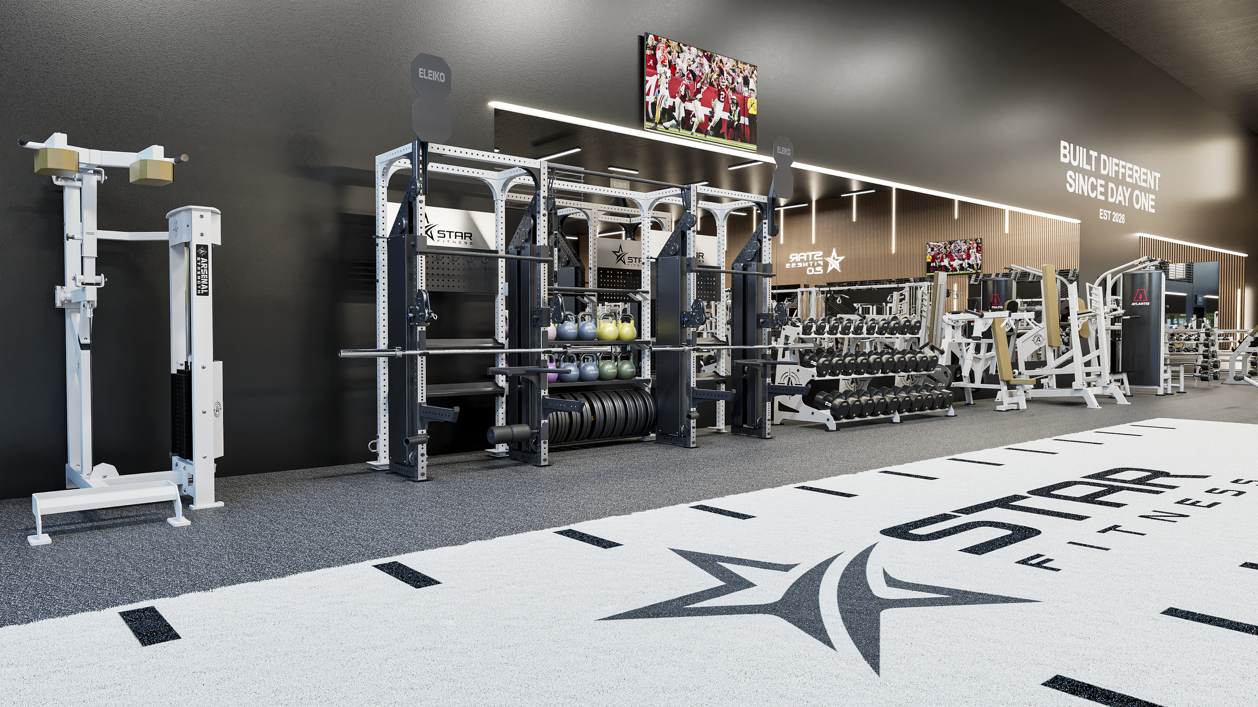 Interior view of a modern gym with various workout equipment, including weight racks, medicine balls, and exercise machines, against a black wall with motivational quotes and sports images.