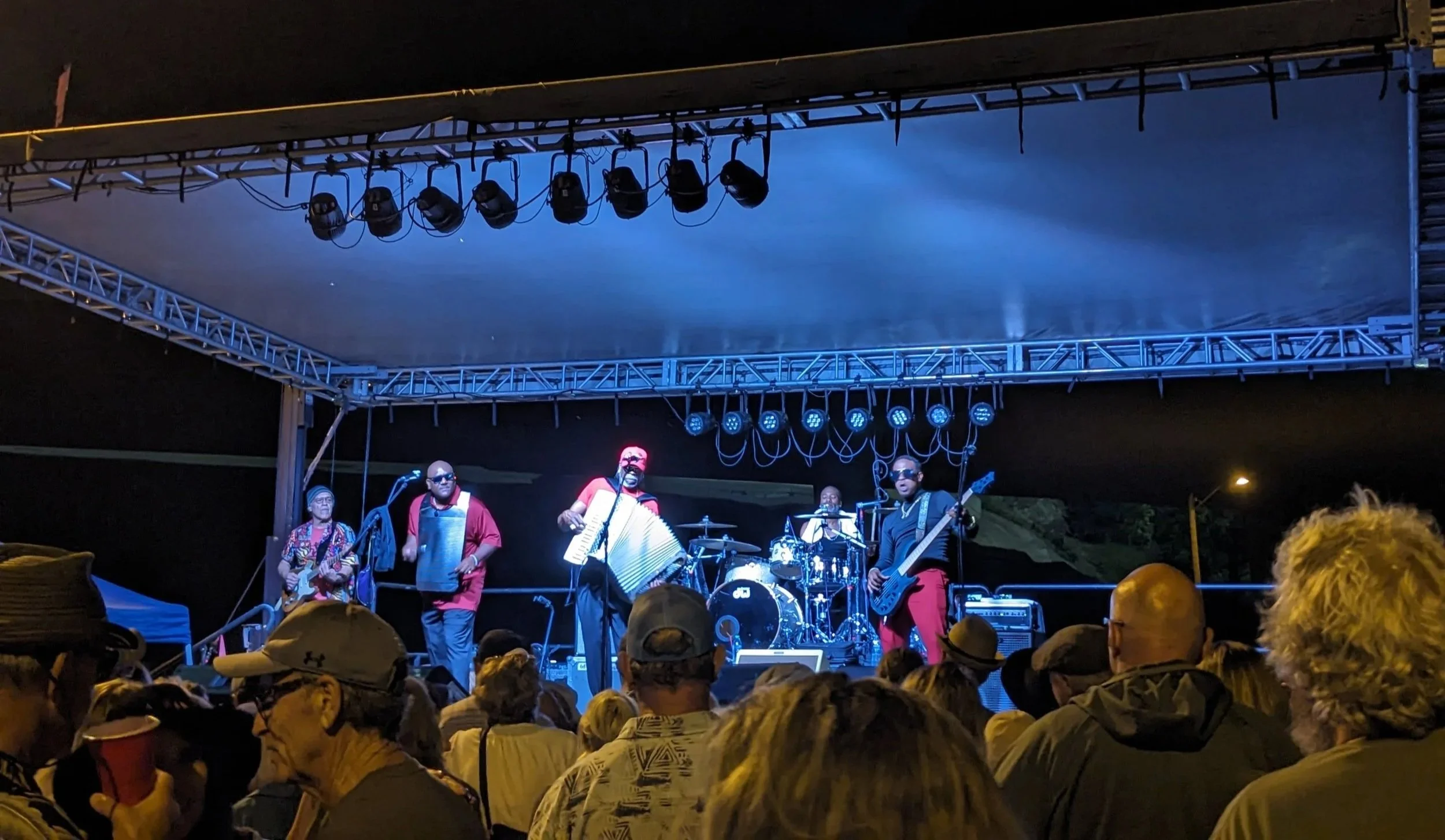 band under lights playing music on stage