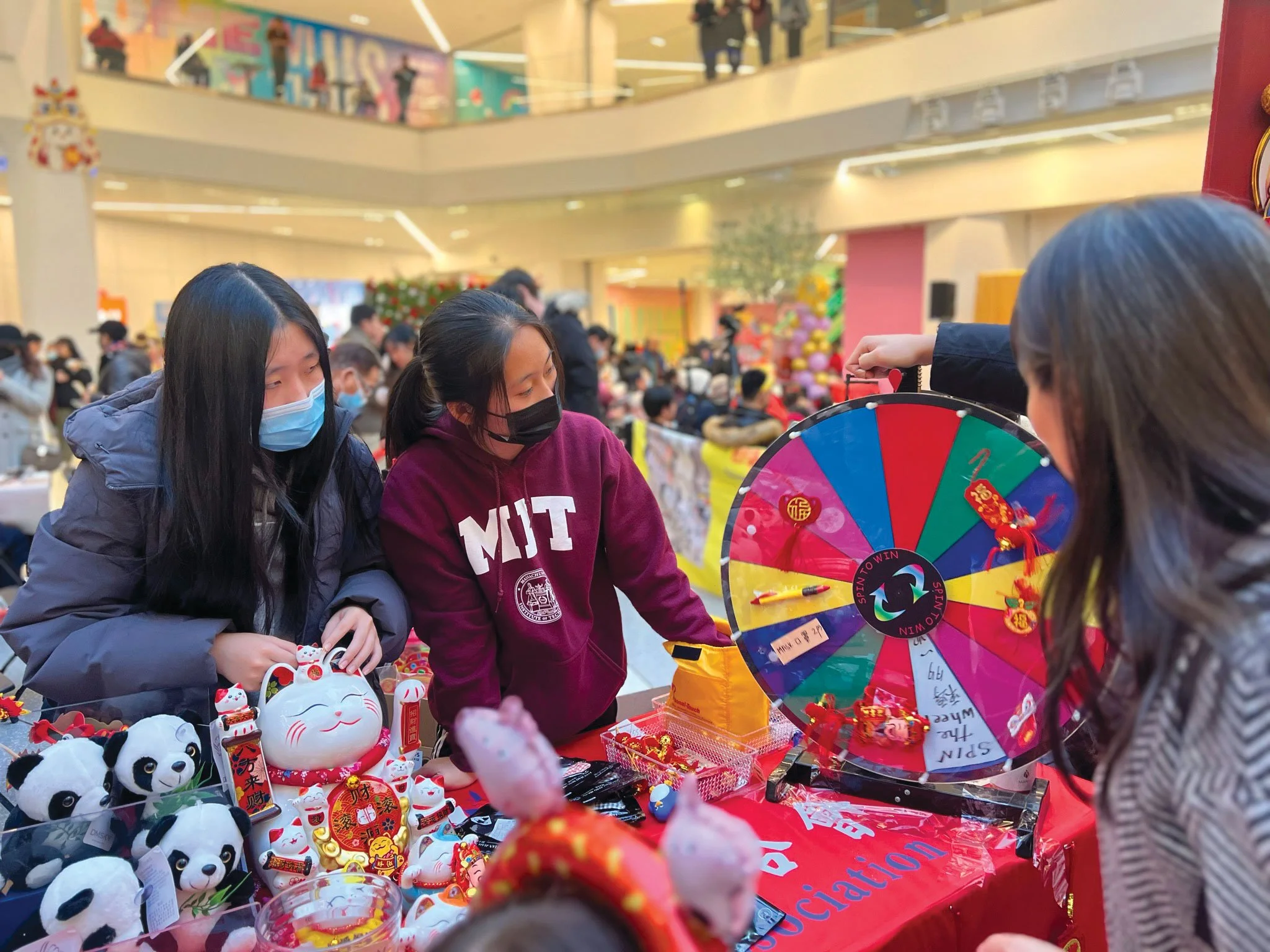 Teens at a cultural booth participate in activities designed to empower children and youth through community engagement.