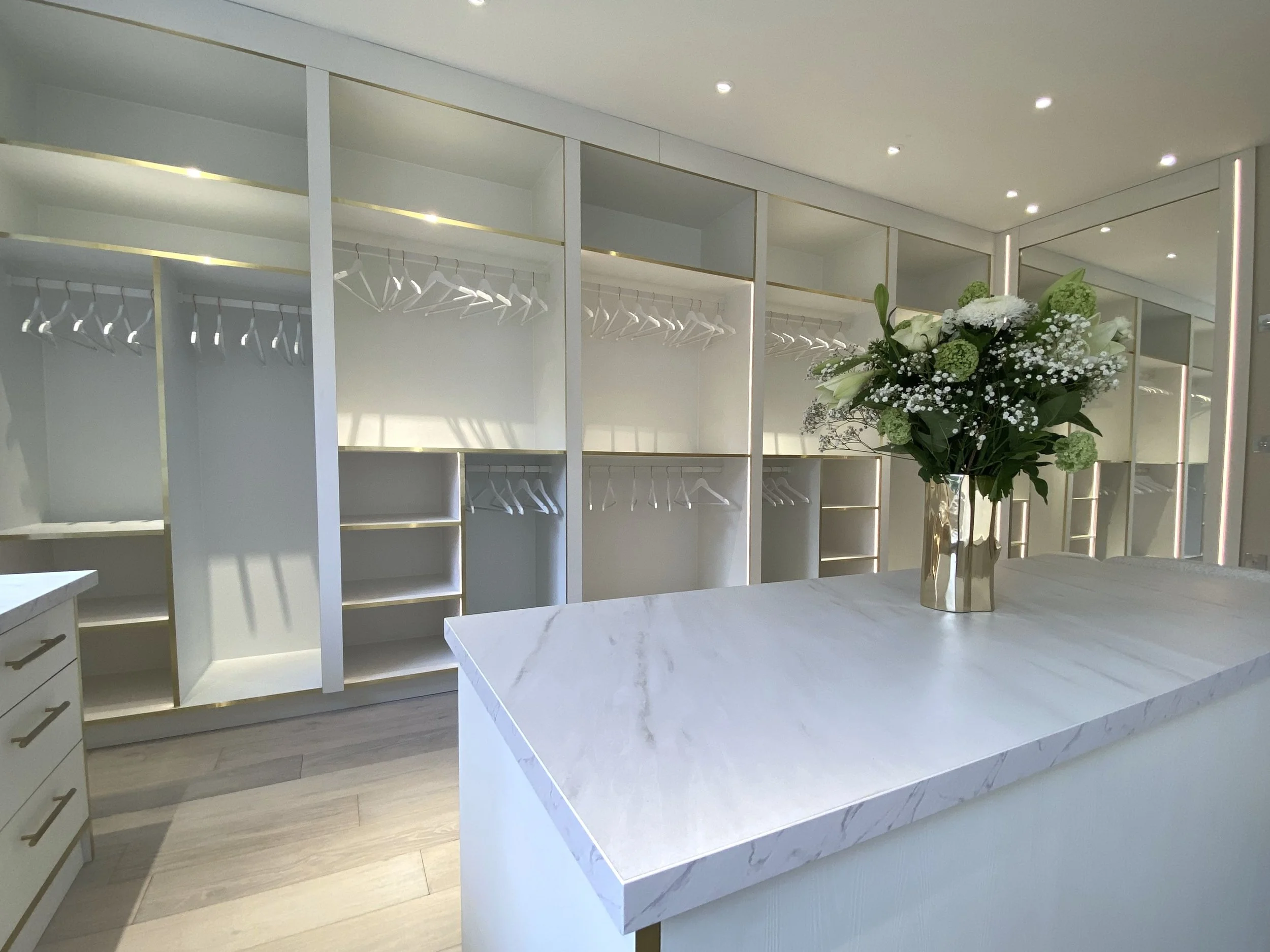 bespoke dressing room in white and marble finishes with integrated lighting