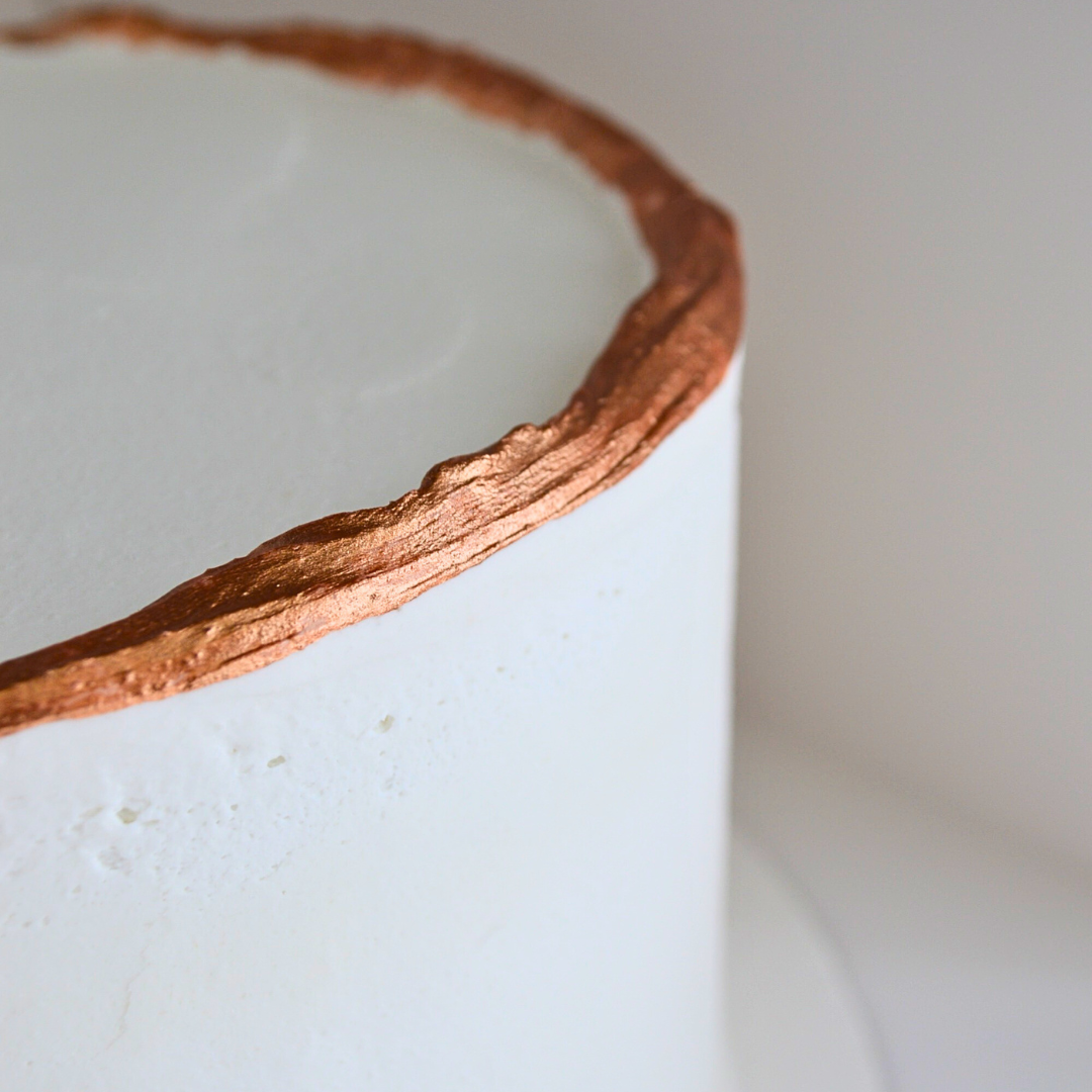 #52. Smoothly frosted white cake with bronze painted on natural top ridge