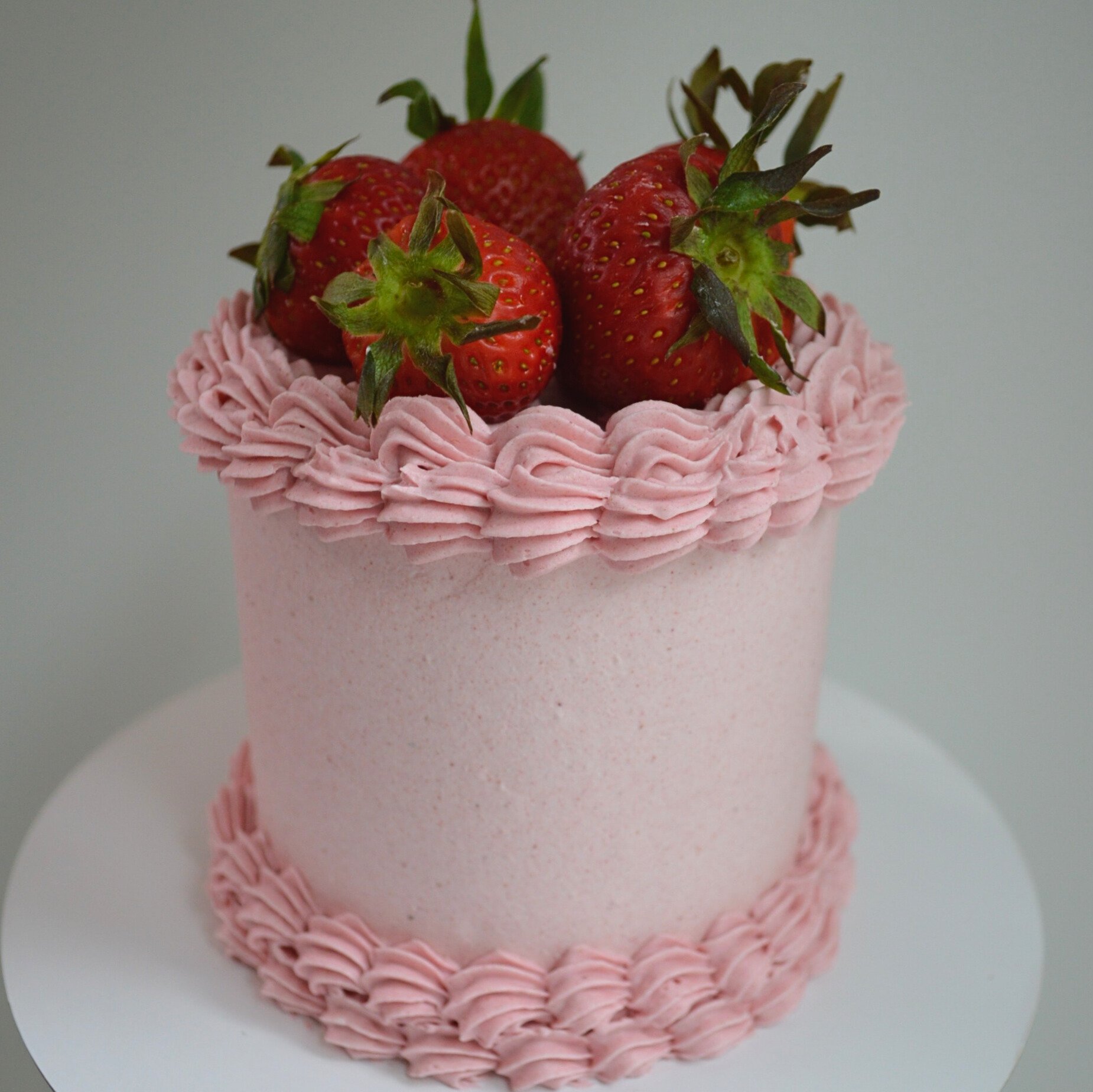 #63. 4" round, 3-layer strawberry cake with a double top and bottom border and fresh, organic strawberries.
