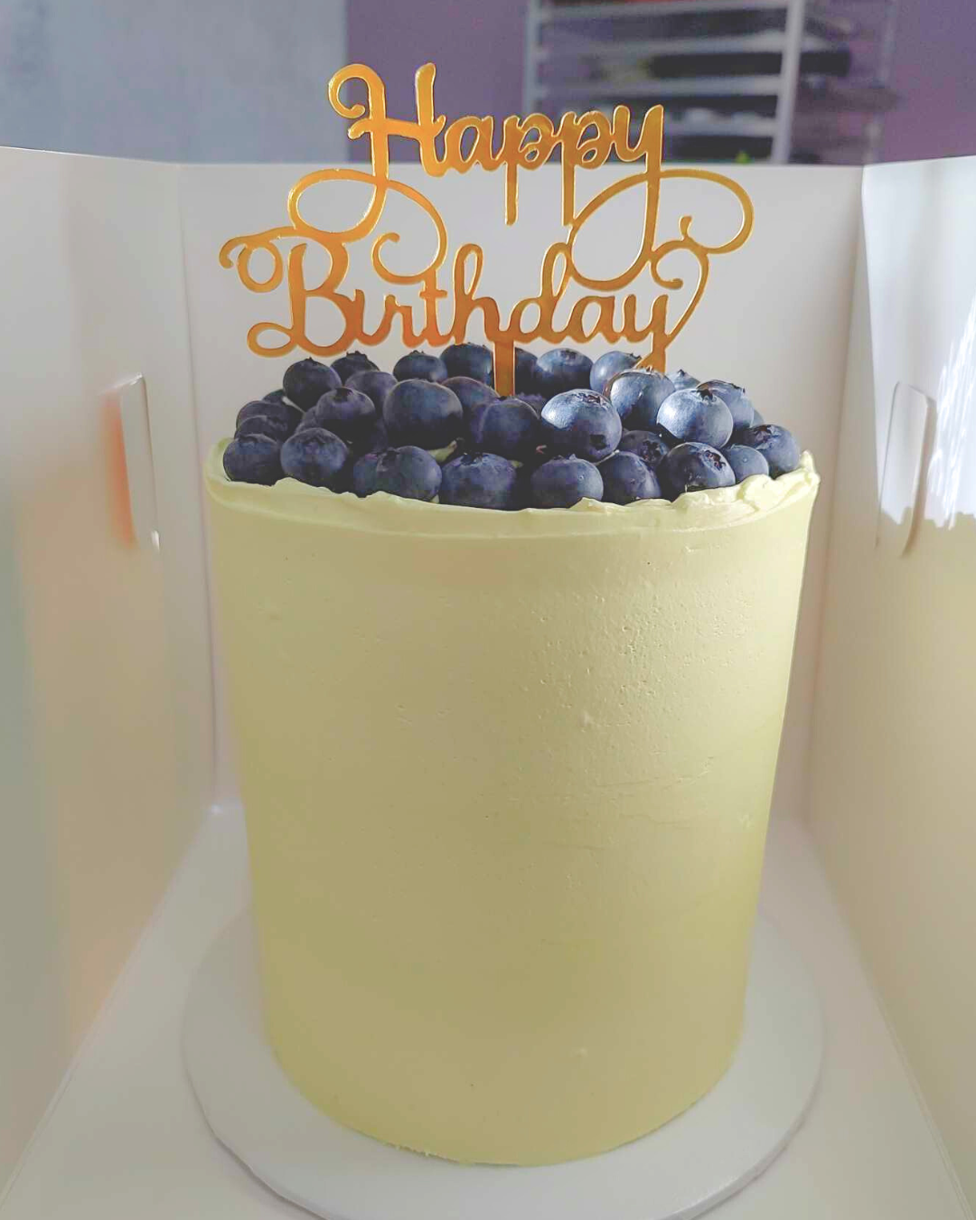 #106. This is a 4" round , 4-layer lemon cake with fresh, organic blueberries.