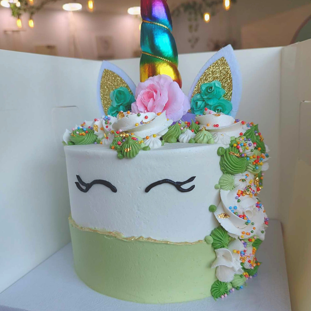 #91. This is a 6" round, 3-layer unicorn cake with a green overlay and edible gold paint on the top ridge of the overlay. You can customize your own unicorn cake in many different ways.