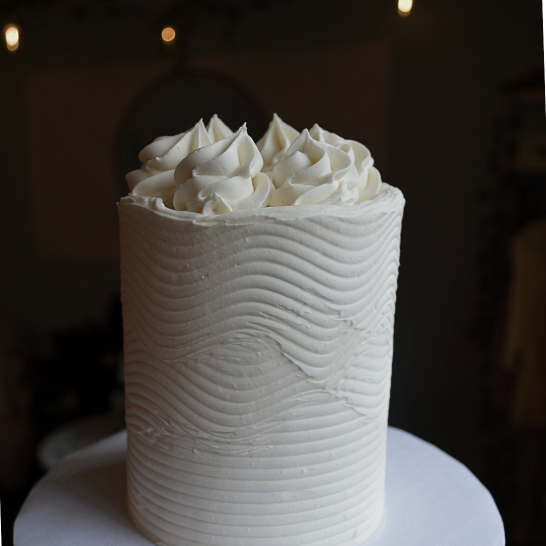 #86. This is a 4" round, 3-layer vanilla cake with a wave pattern and swirls.