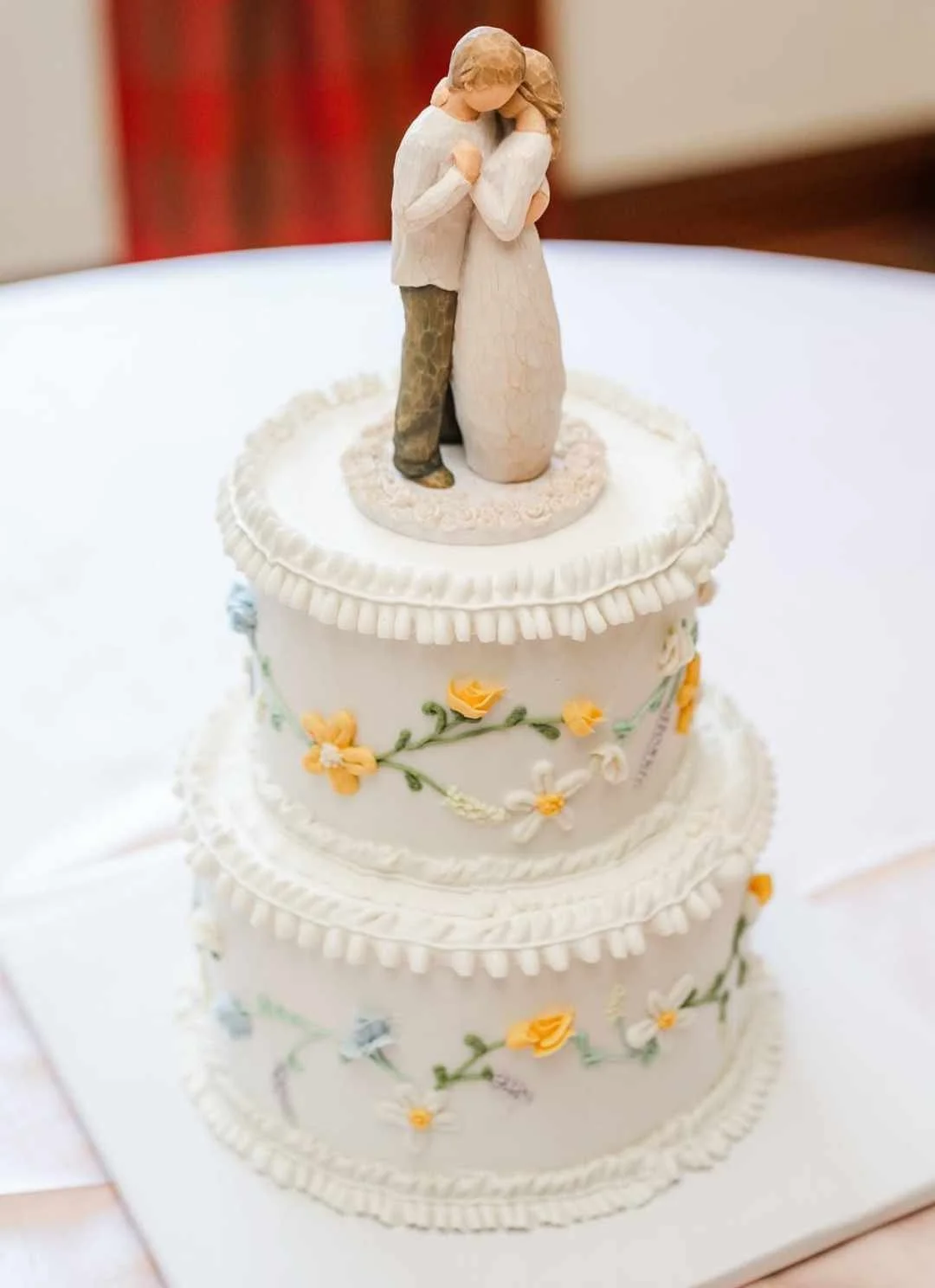 #6. This is a two-tiered 8" round, 3-layer and 6" round, 3-layer wedding cake with floral hand-piping around the outside and ruffle borders.