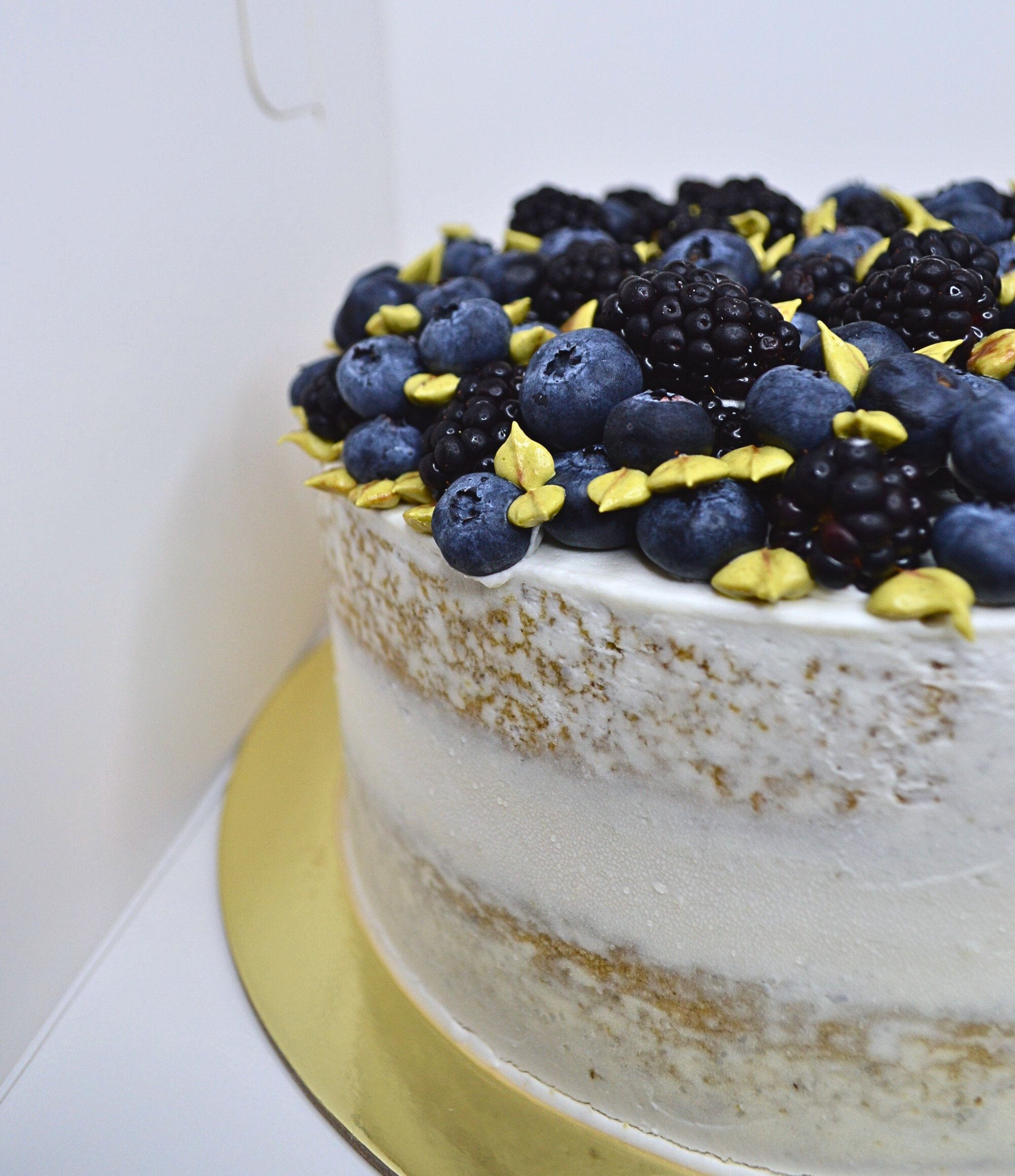 #49. Lemon naked cake with fresh berries and piped leaves.