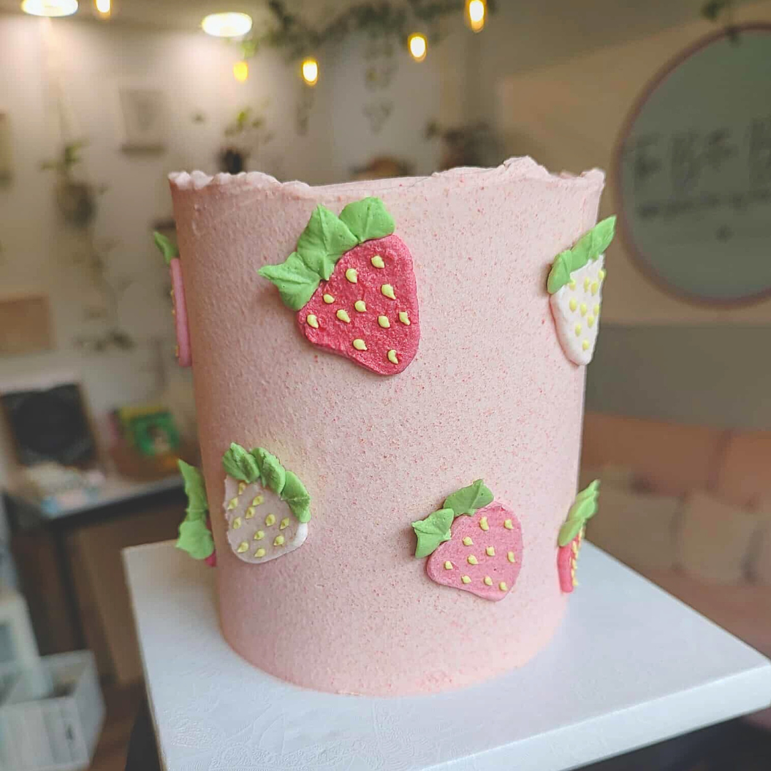 #98. This is a 4" round, 3-layer strawberry cake with hand-piped strawberries on the sides of the cake.