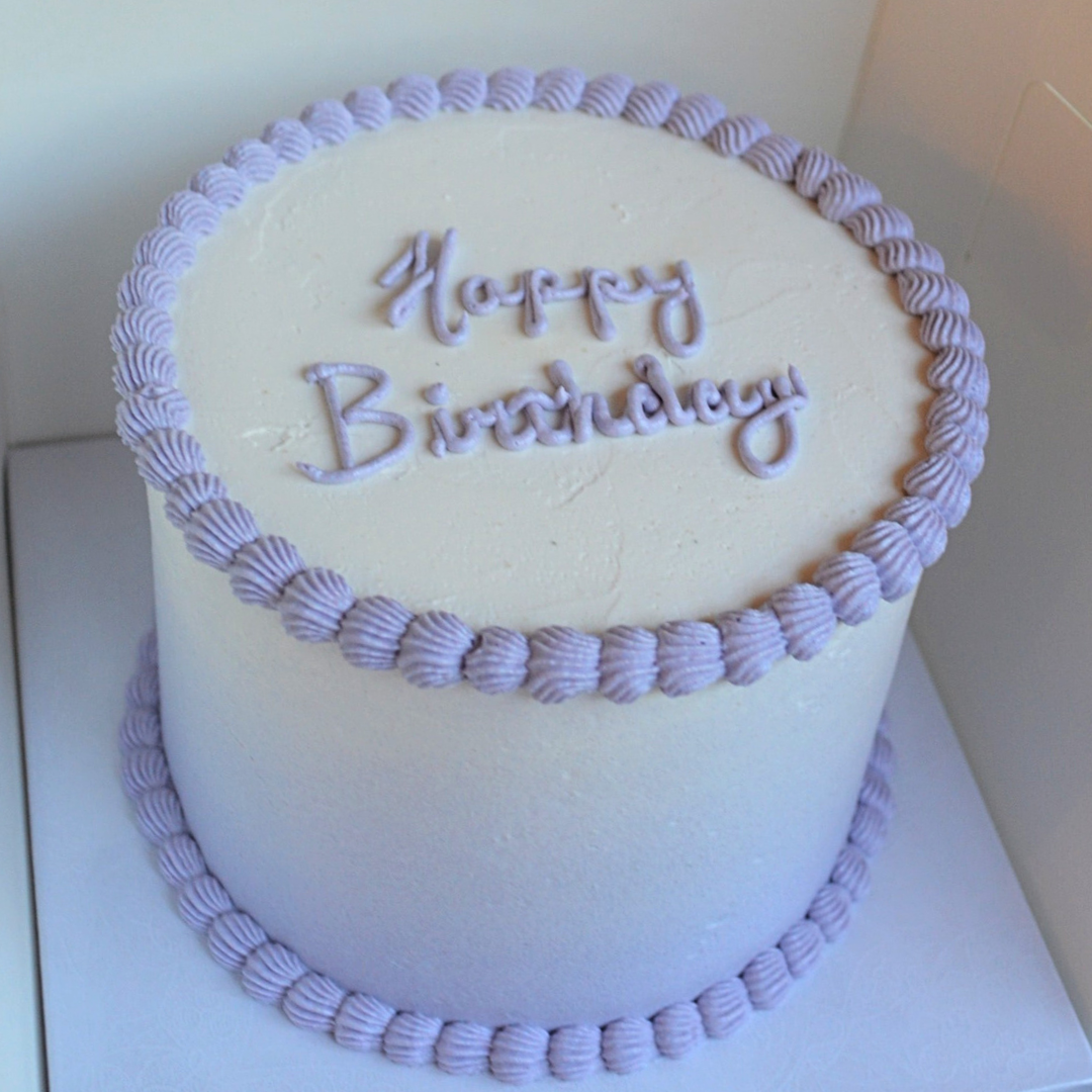#117. This is a 6" round, 3-layer purple to white ombre cake with a top and bottom shell border.