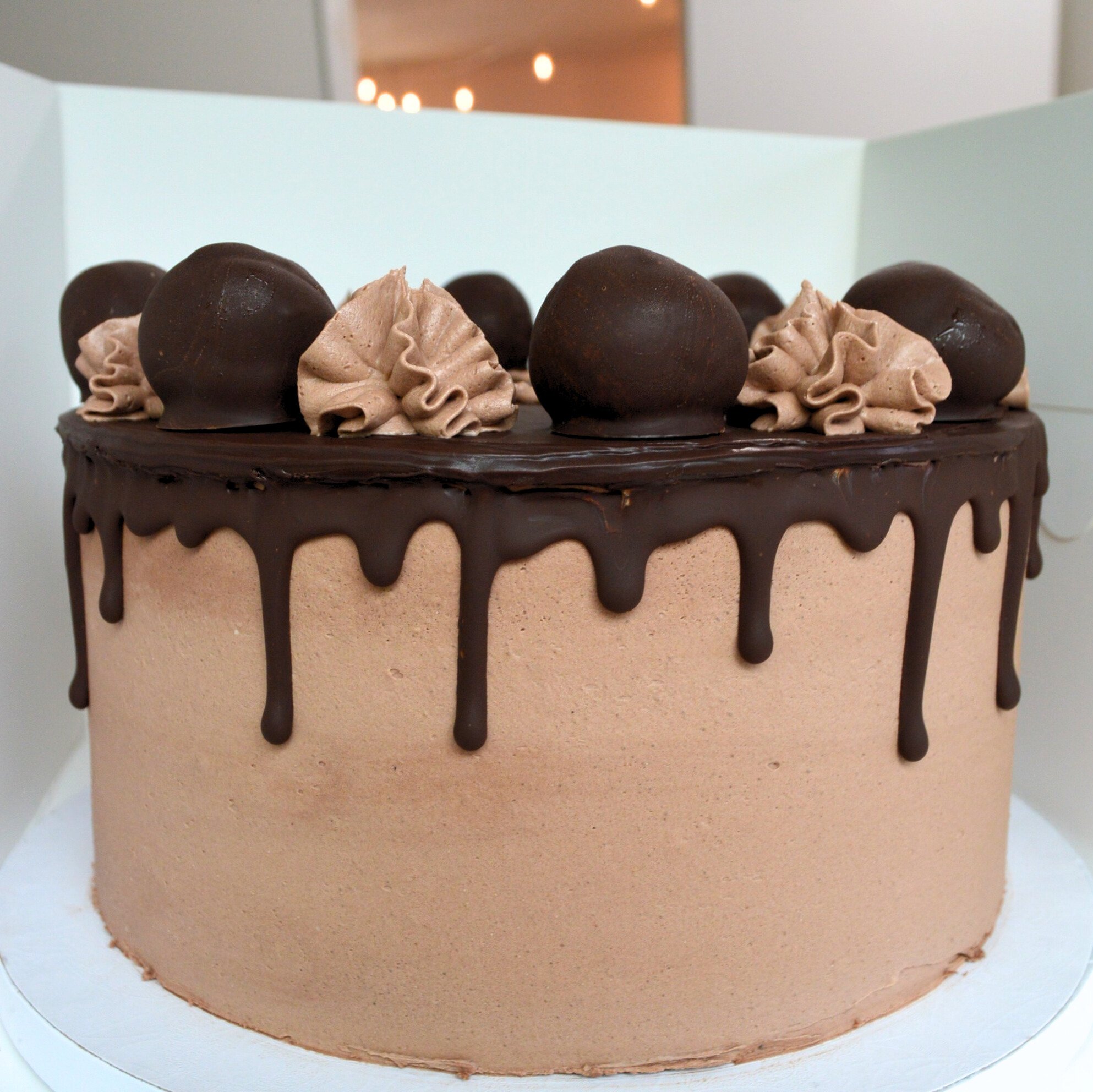 #10. Chocolate cake with a dark chocolate drip, chocolate frosting dollops and handmade chocolate truffles.
