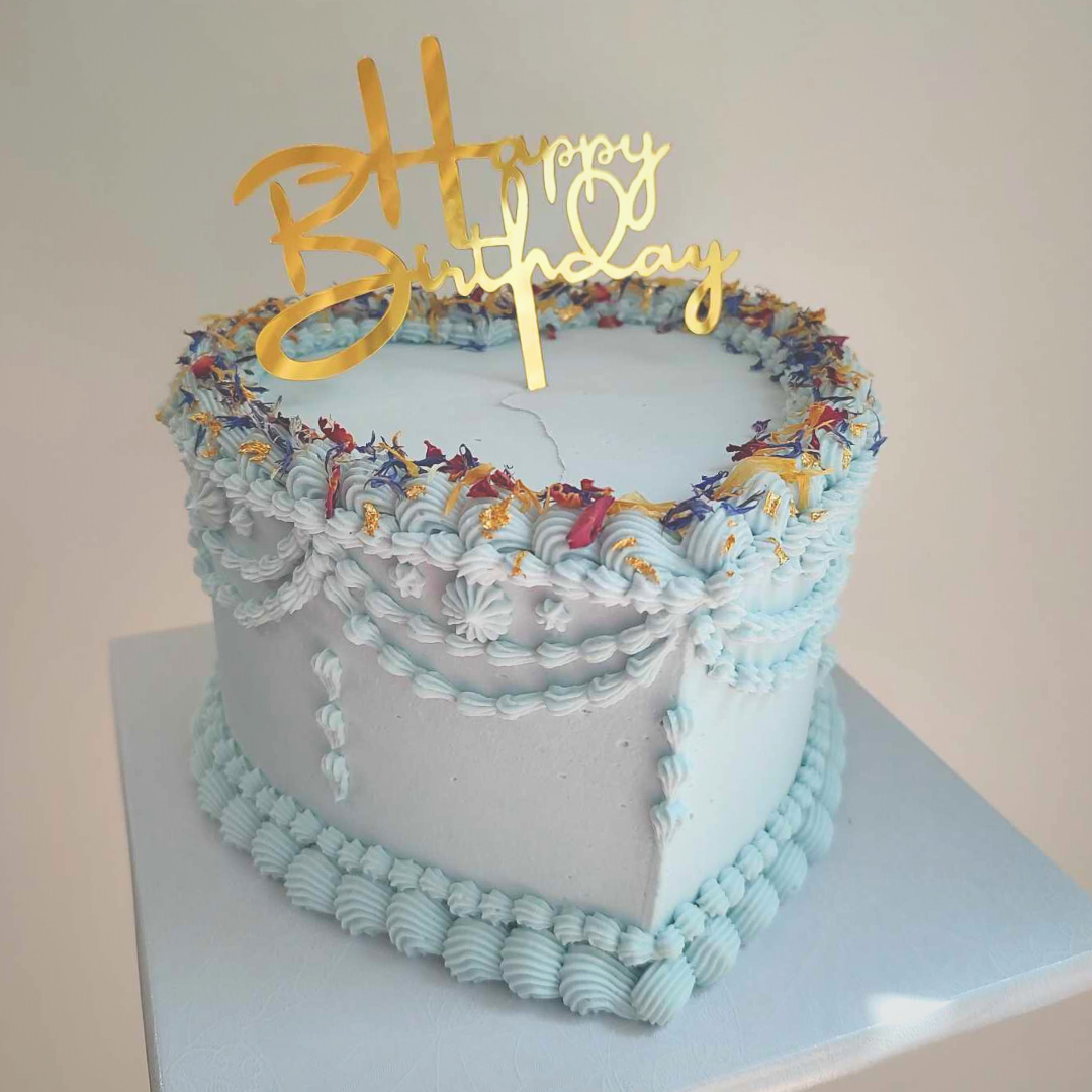 #103. This is a 6" heart-shaped, 3-layer vintage style cake with edible pressed flower petals.