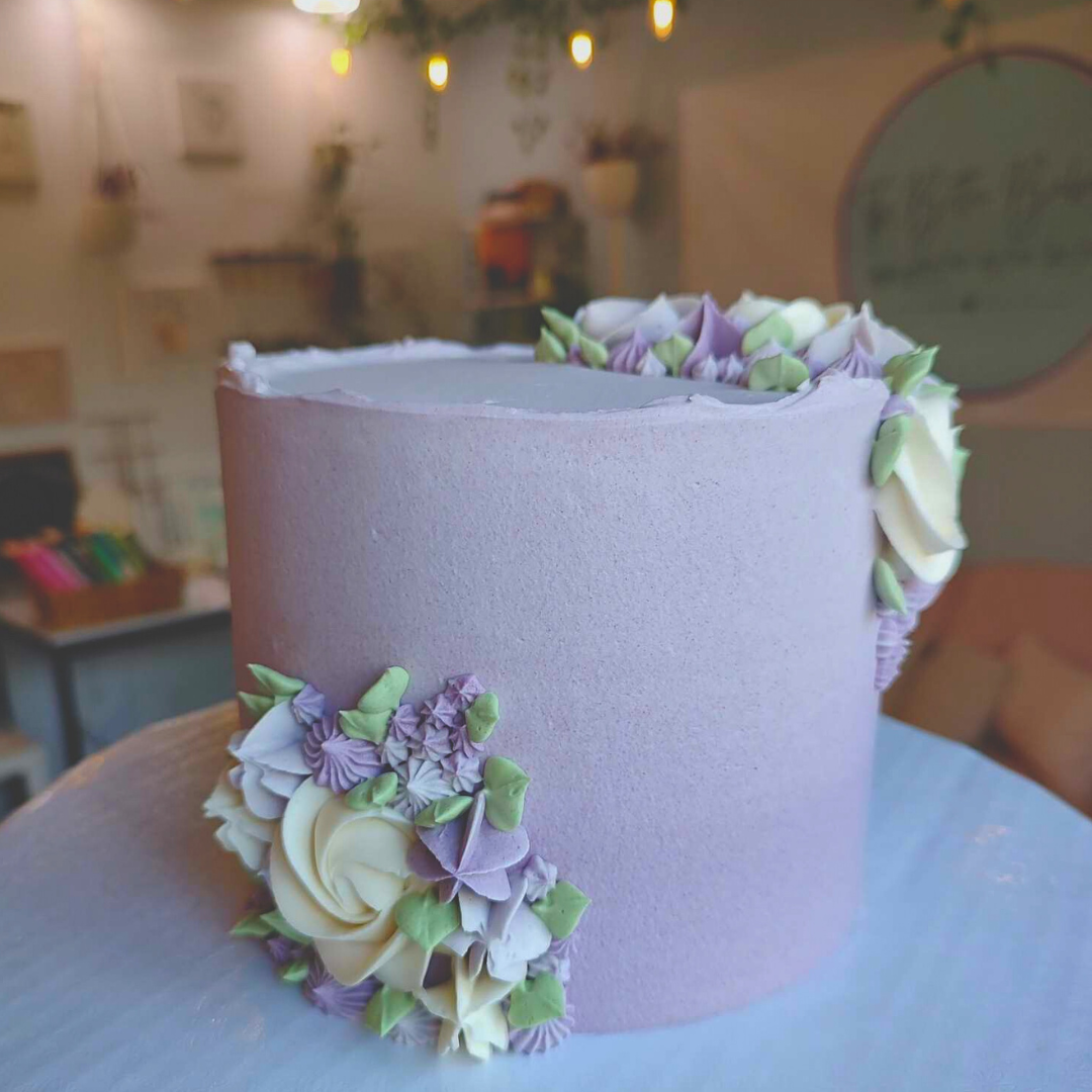 #105. This is a 6" round , 3-layer purple ombre cake with hand-piped frosting florals.