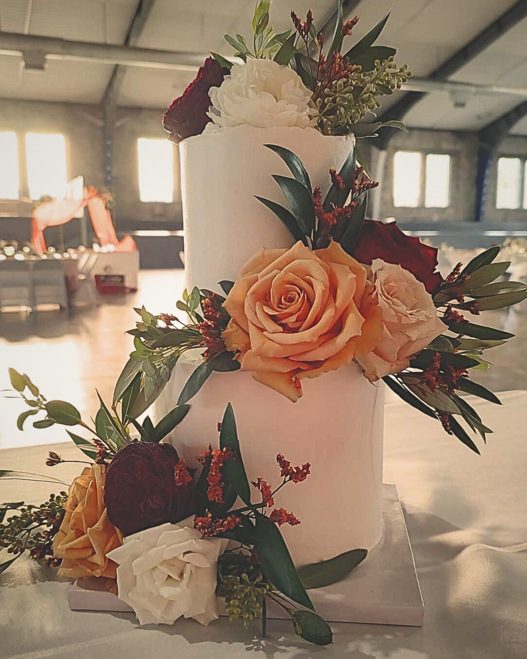 #107. This is a two-tiered wedding cake with fresh florals. The sizes of the tiers are a 6" round , 3-layer and a 4" round , 3-layer tier.