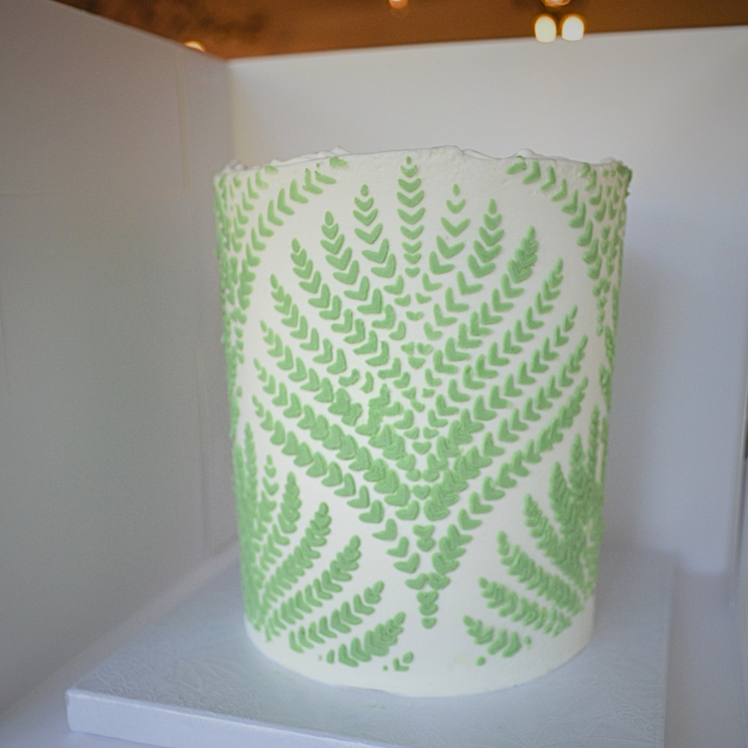 #115. This is a 4" round, 3-layer white cake with a green fern design overlay.