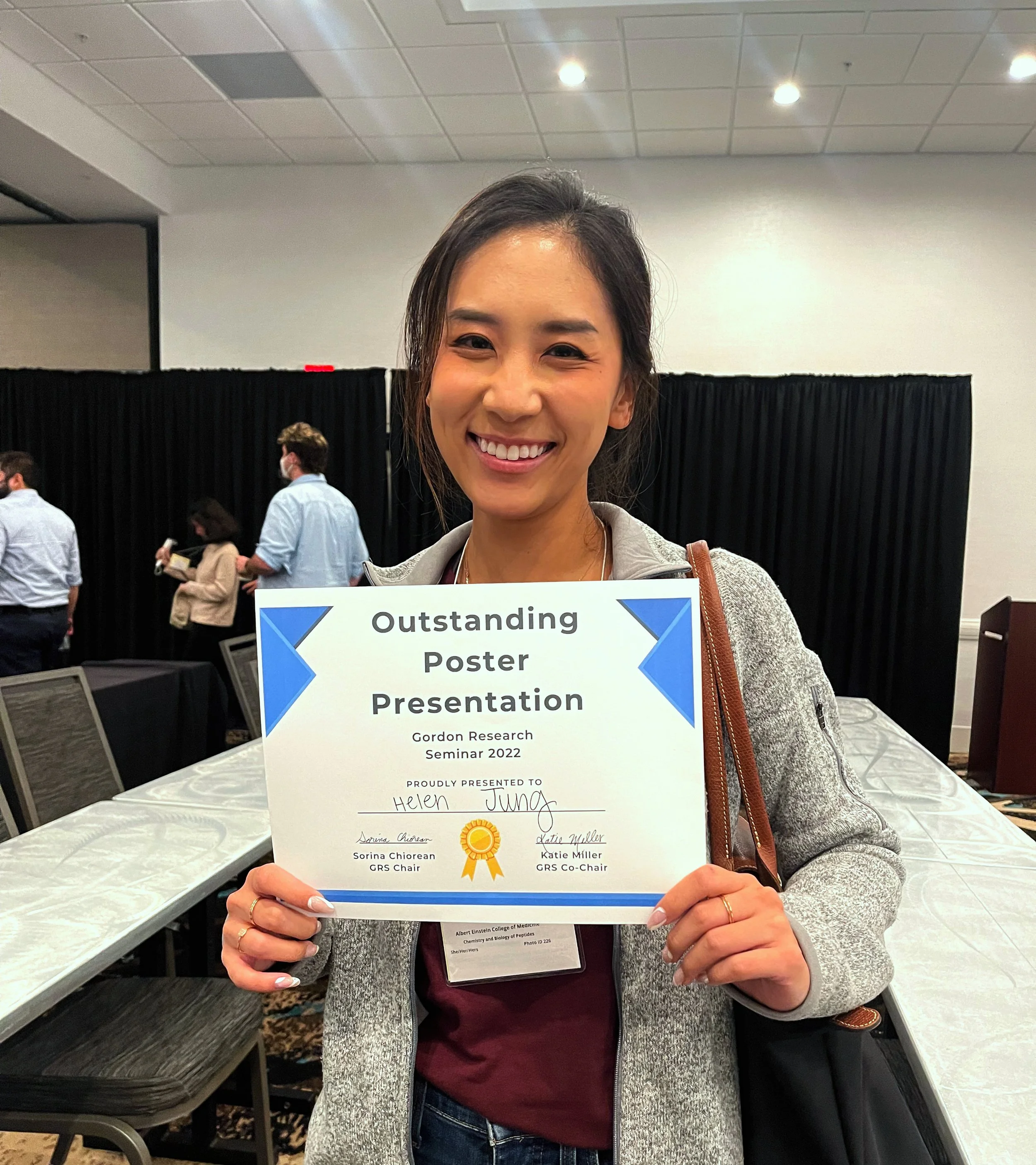 Helen holding up an award for outstanding poster presentation at the Gordon Research Seminar