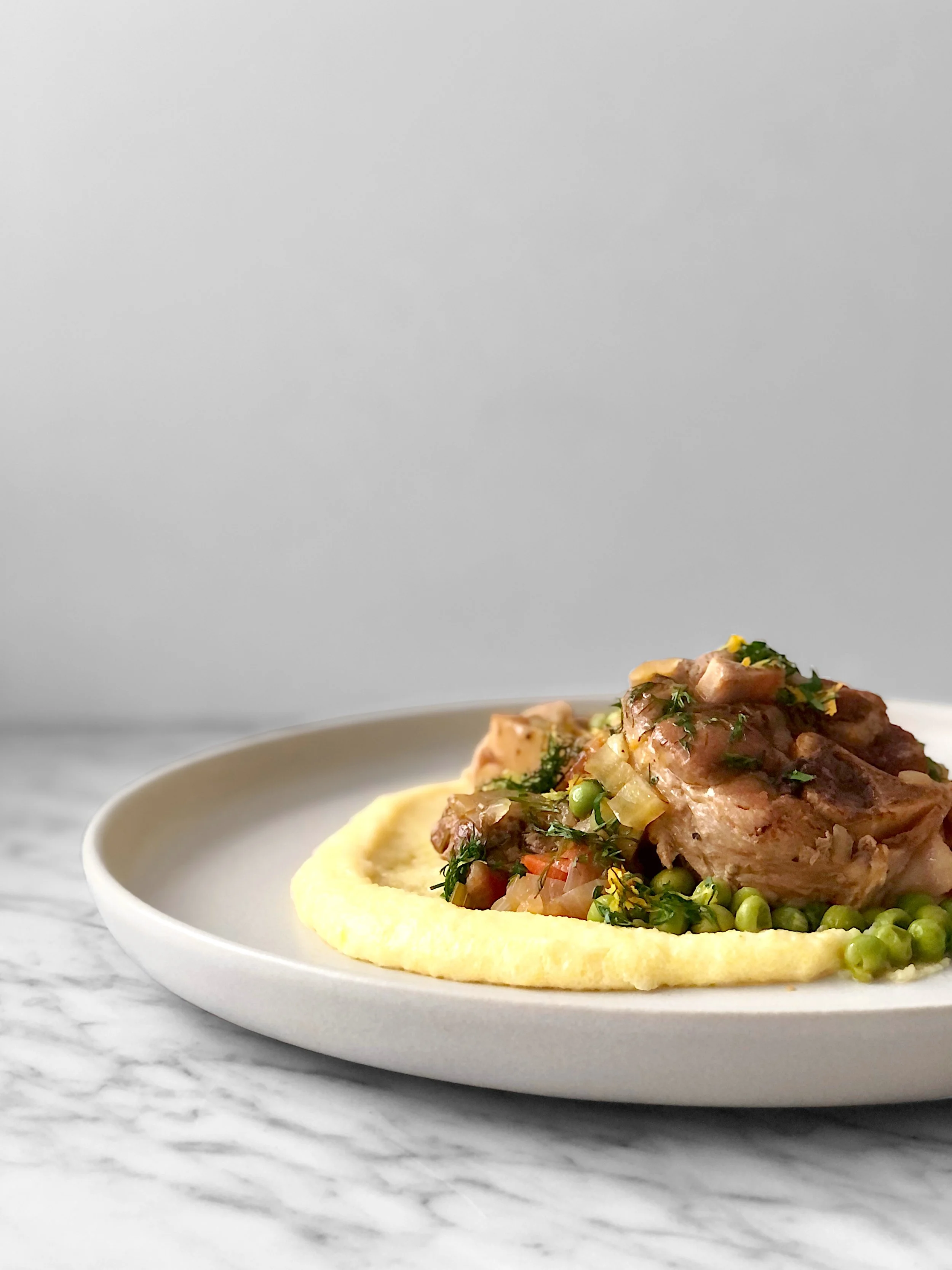 Osso buco de porc, petits pois et polenta crémeuse au parmesan