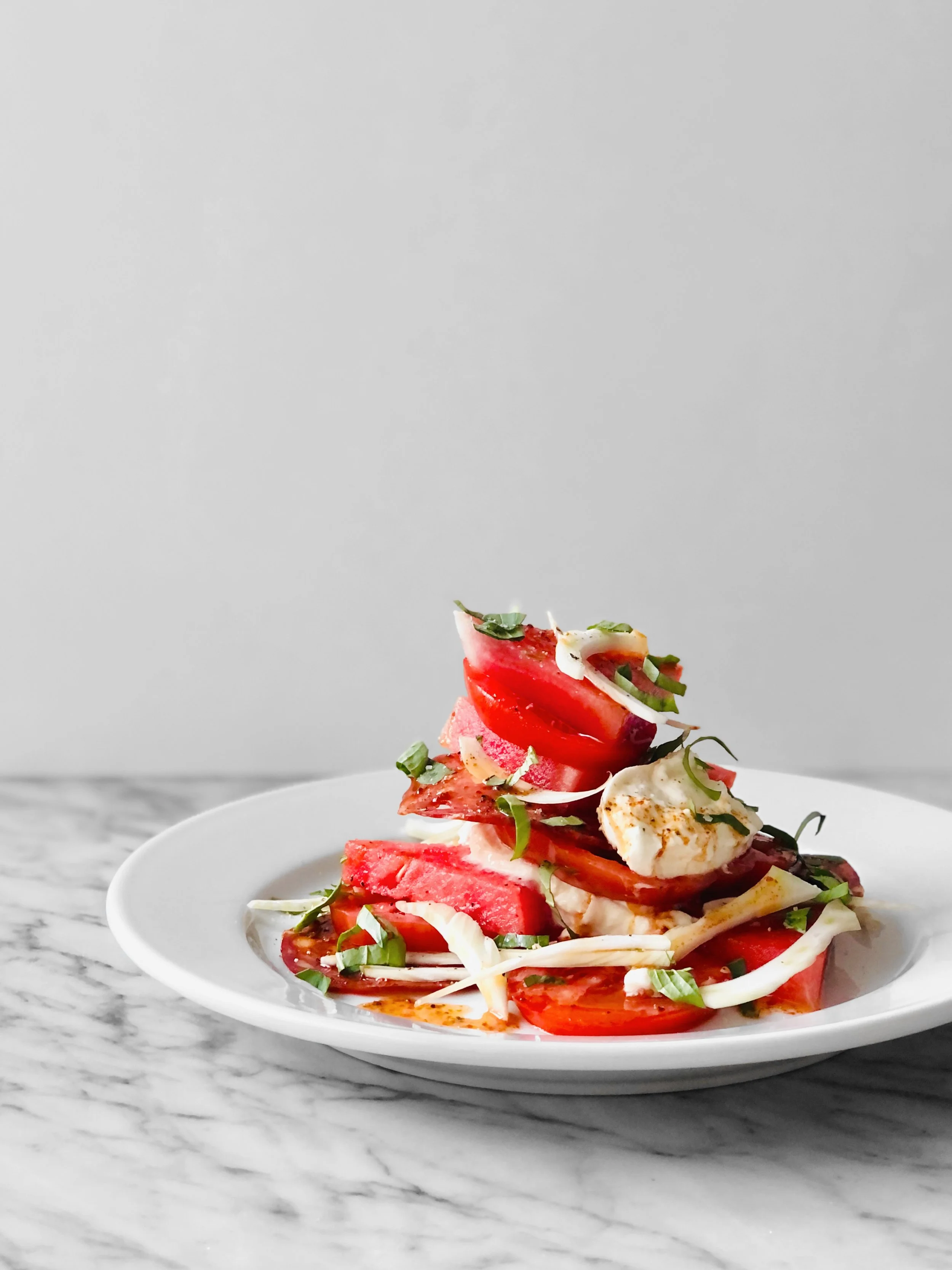 Salade étagée tomate-pastèque, burrata, chorizo et vinaigrette au paprika fumé