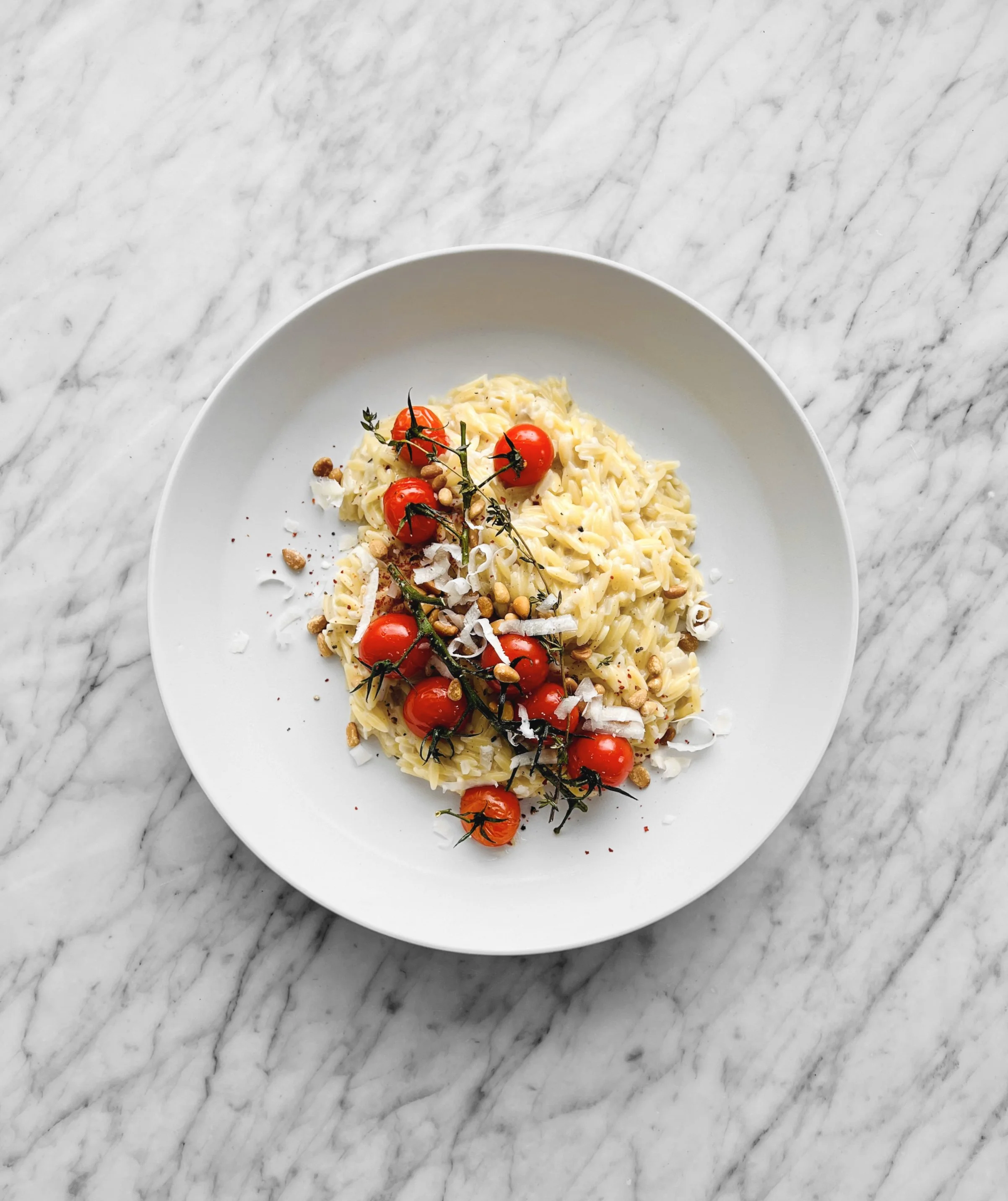 Orzo au parmesan façon risotto, tomates et noix de pin rôties