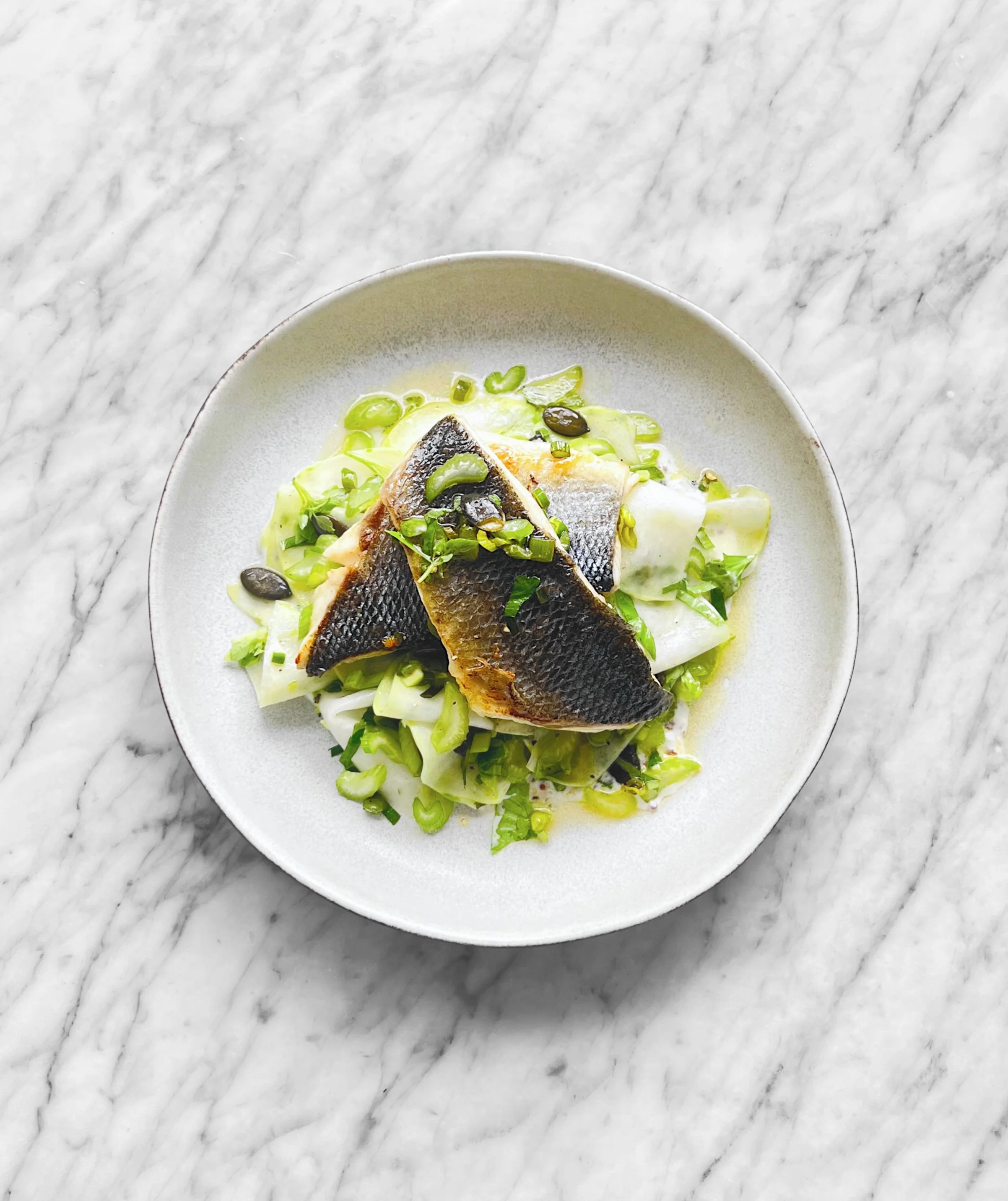 Bar poêlé et salade de chou-rave aux herbes et à la fleur d'ail