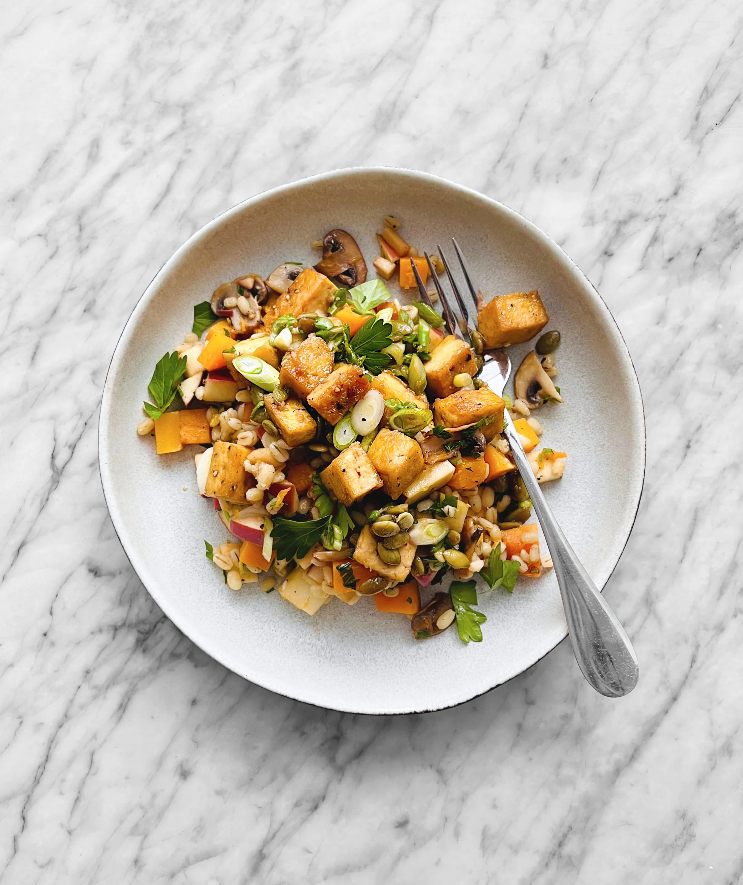 Salade chaude d'orge, champignons, courge et pomme avec tofu caramélisé
