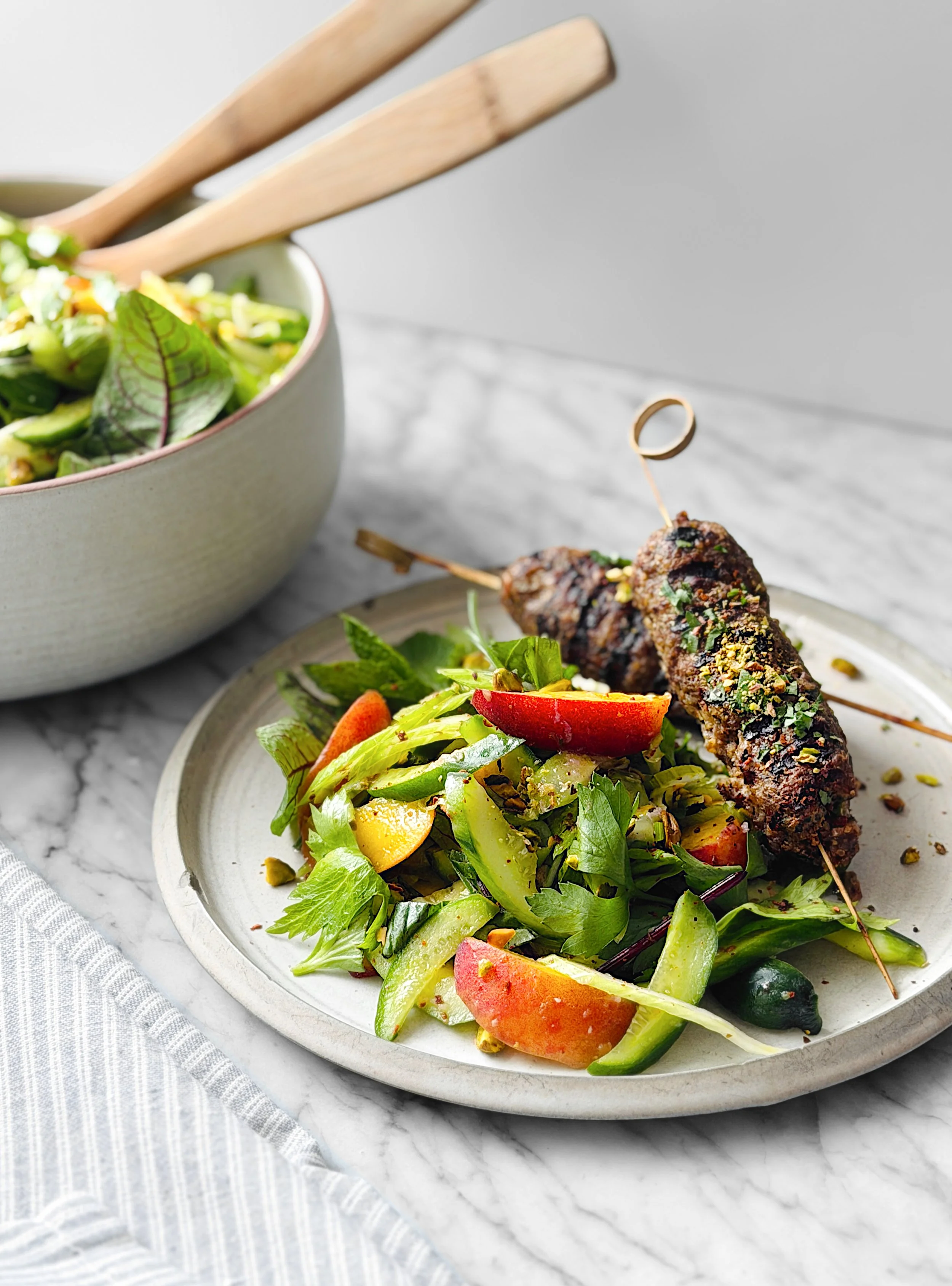 Salade de concombre aux pêches, herbes et pistaches avec keftas d'agneau