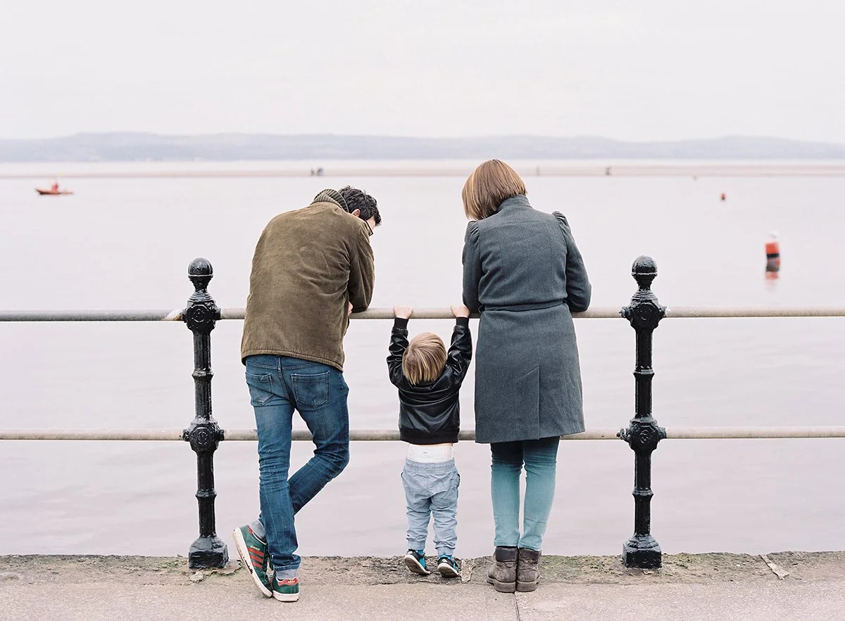 Portrait of a little boy with his parents looking out over the Marine Lake in West Kirby