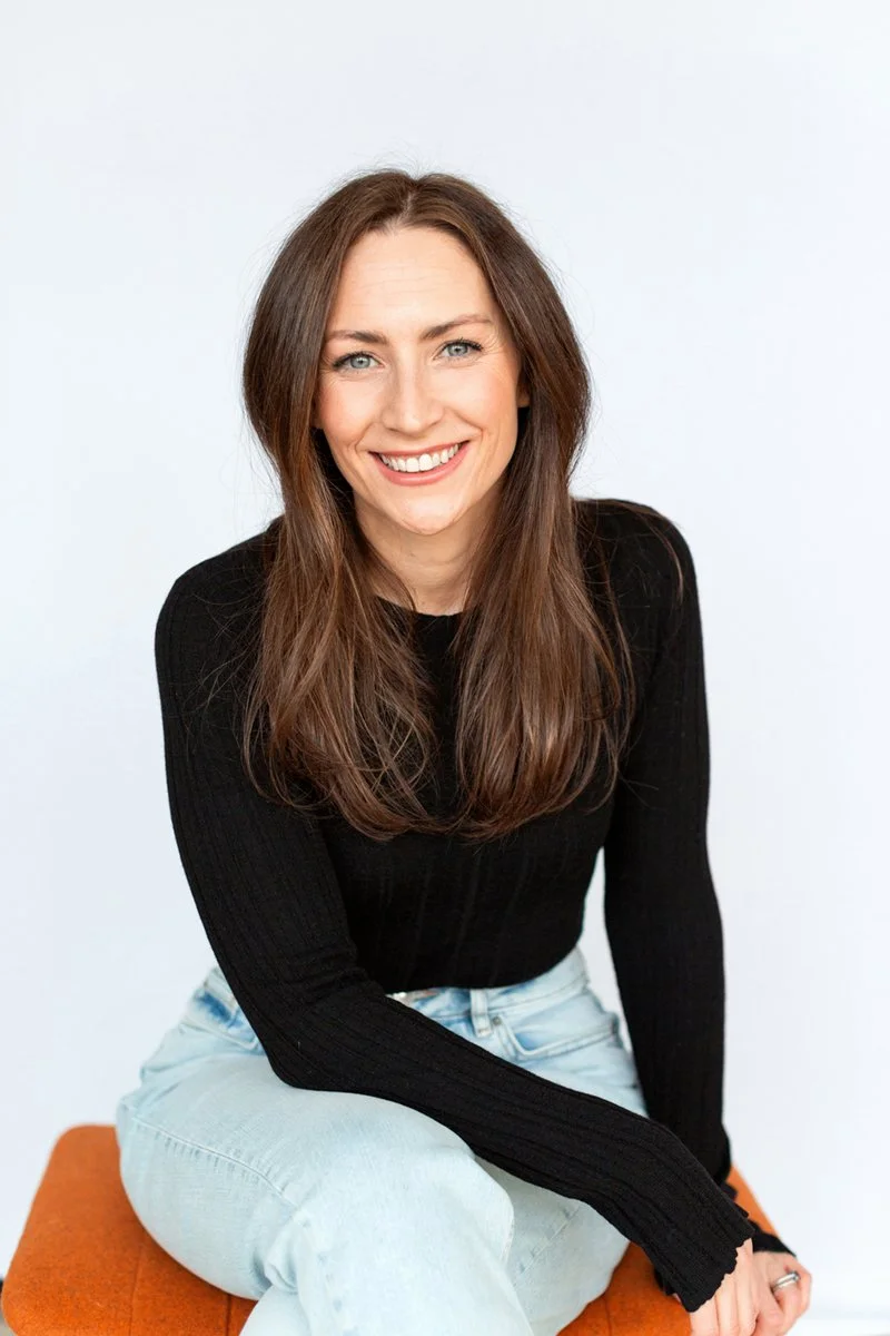 Relaxed portrait of a woman sitting and happily smiling to camera