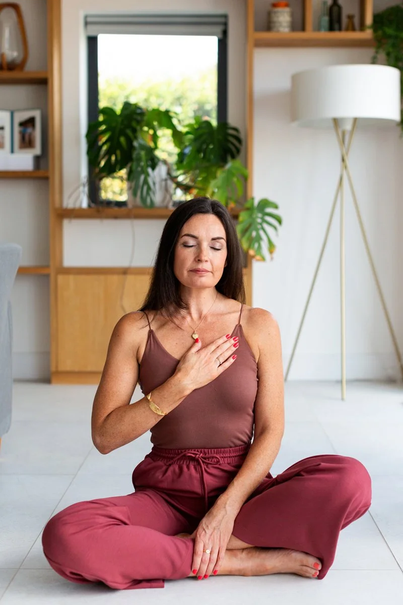 Personal brand portrait of a somatic healer with her hand on her heart