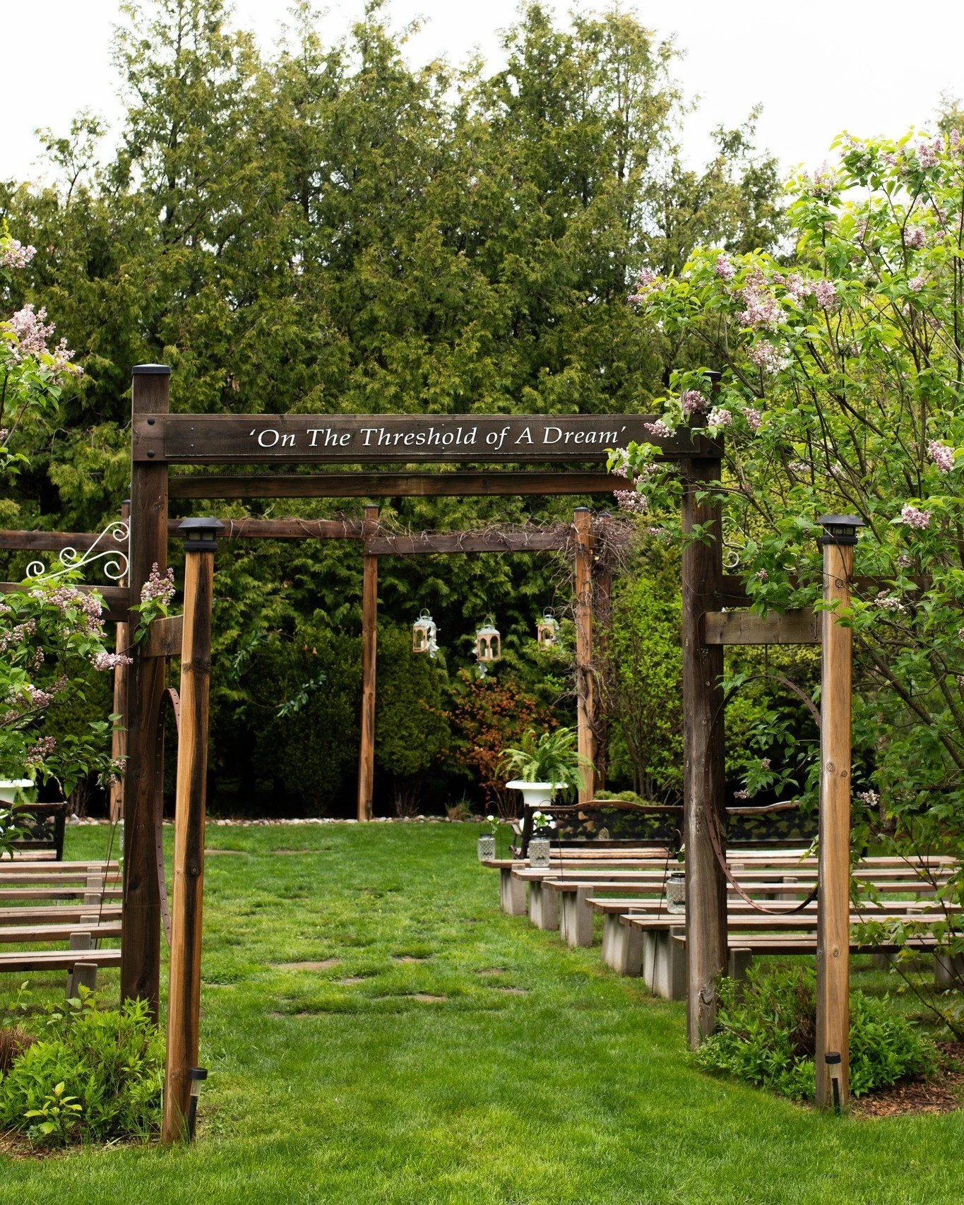 Under a natural wood-beamed archway, wrapped in seasonal vines and laced with whimsical lanterns, two people become one. 💍

The ceremony area at Northview Gardens was designed with reverence for that single, sacred moment. Evergreens frame the edges